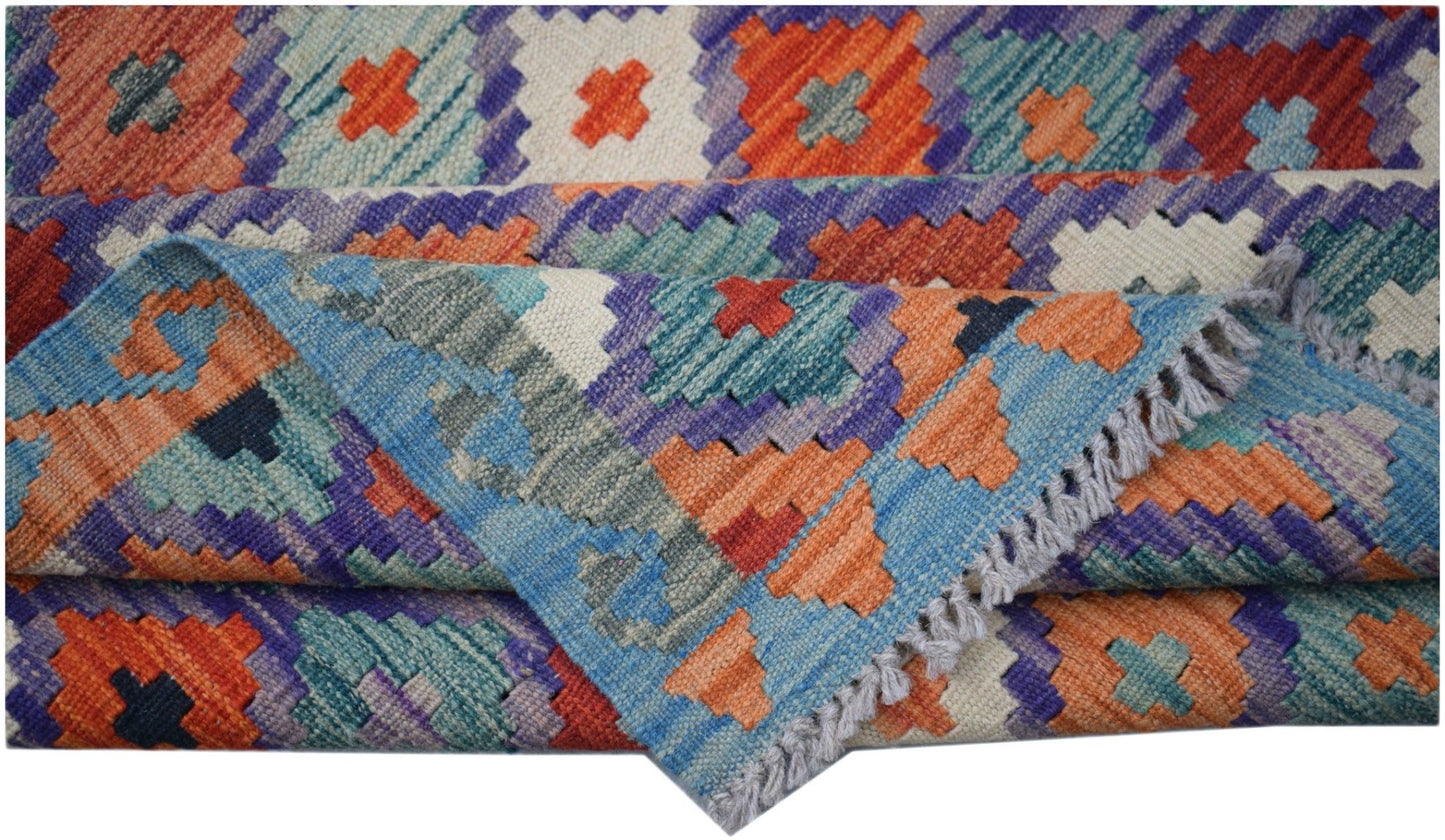 A handmade Afghan Maimana kilim rug featuring a vibrant geometric pattern in wool.