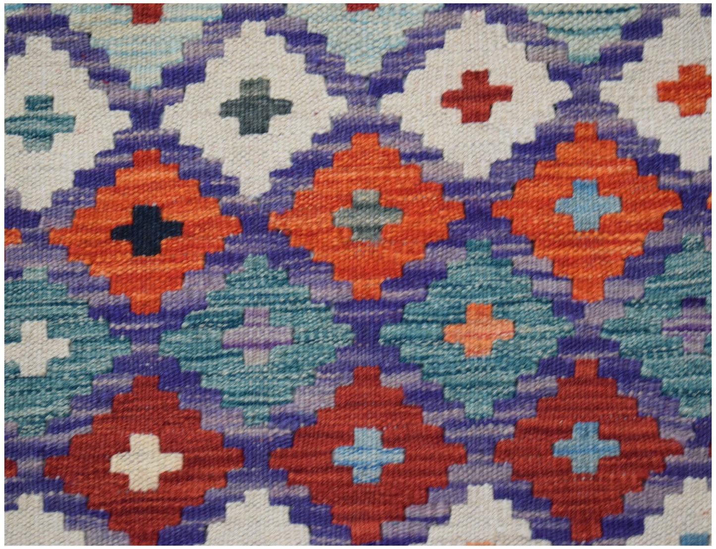 Handwoven Afghan Maimana kilim featuring a geometric diamond pattern in vibrant wool colors.