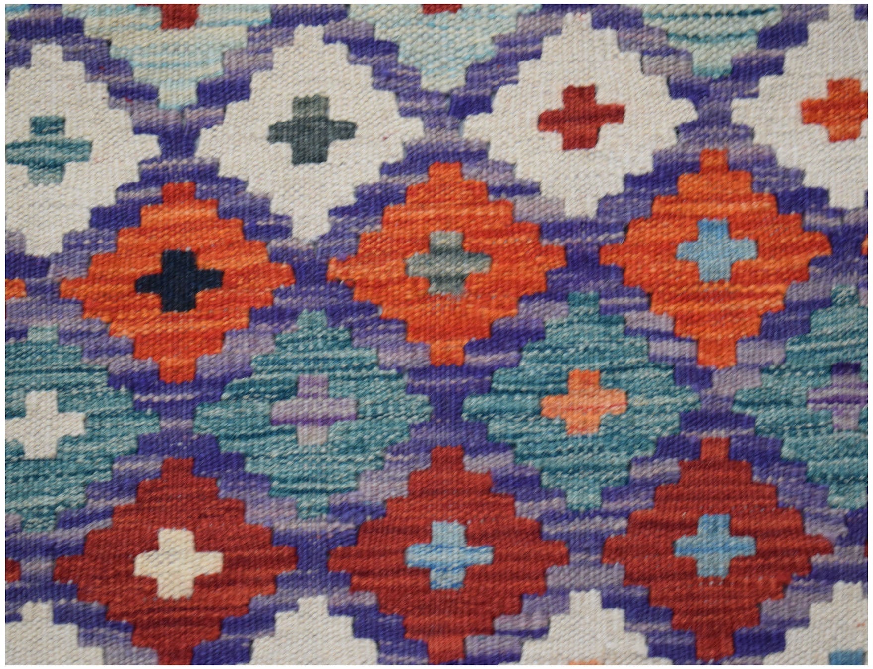Handwoven Afghan Maimana kilim featuring a geometric diamond pattern in vibrant wool colors.
