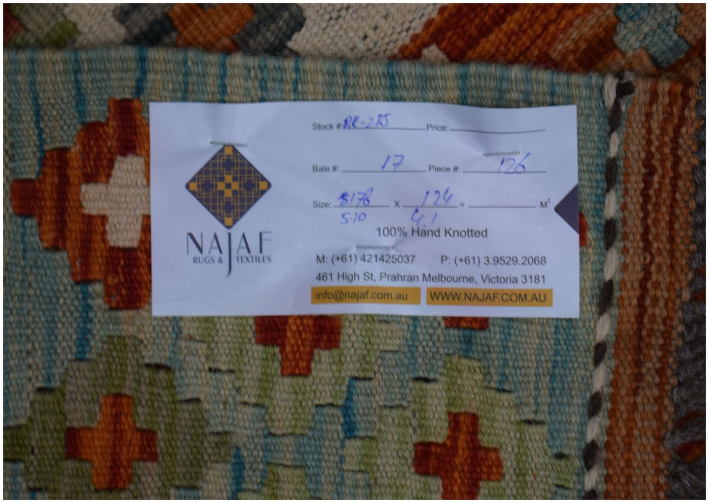 An Afghan Maimana Kilim rug featuring a geometric pattern in vibrant orange, blue, and cream tones.