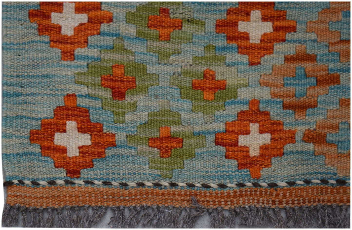Handwoven Afghan Maimana kilim rug featuring a geometric pattern in orange, green, and blue.