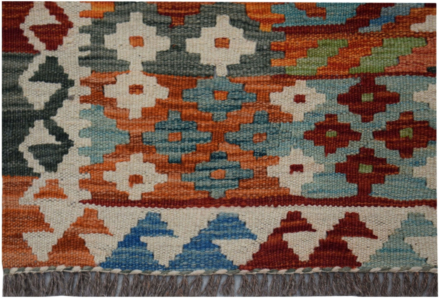 A handwoven Afghan Maimana kilim rug featuring a geometric pattern in orange, blue, and red.