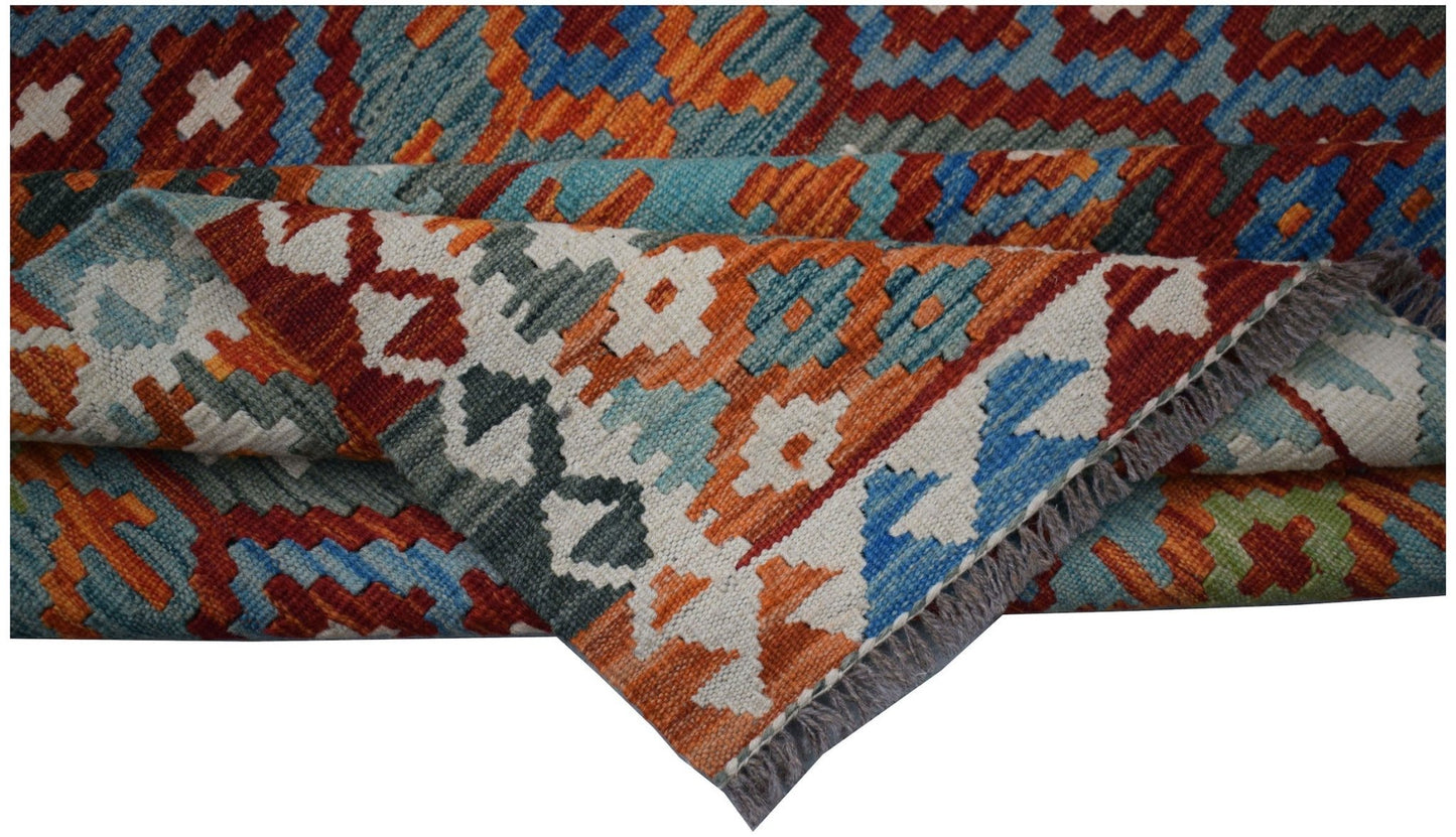 A handwoven Afghan Maimana kilim rug featuring a geometric pattern in vibrant orange and blue tones.