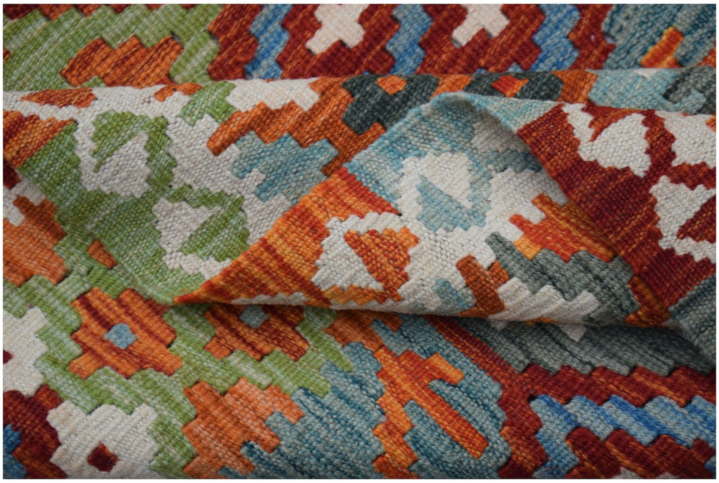 A handwoven Afghan Maimana kilim rug featuring a vibrant geometric pattern in wool.