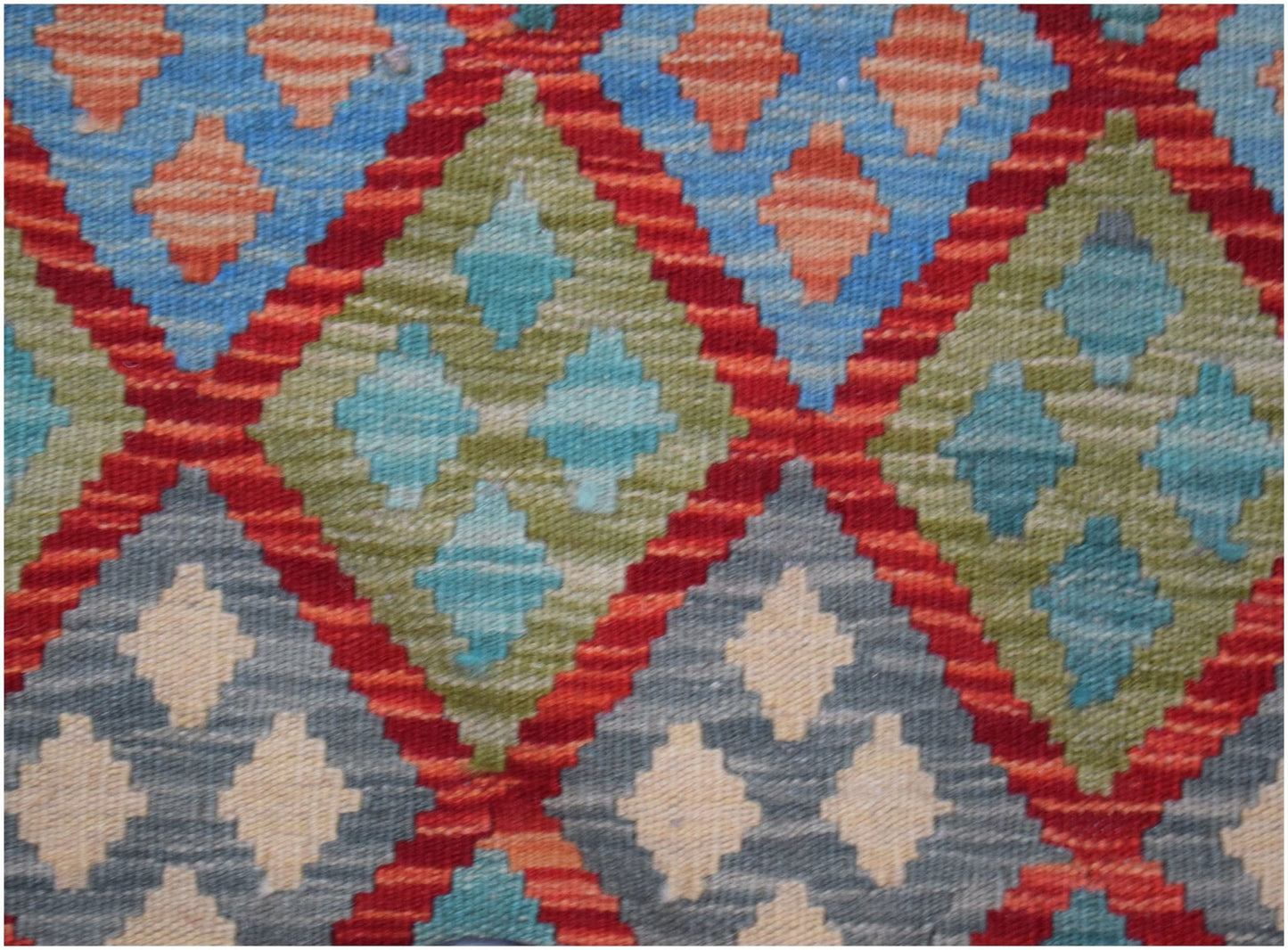 Handwoven Afghan Maimana kilim featuring a geometric diamond pattern in blue, green, and red.