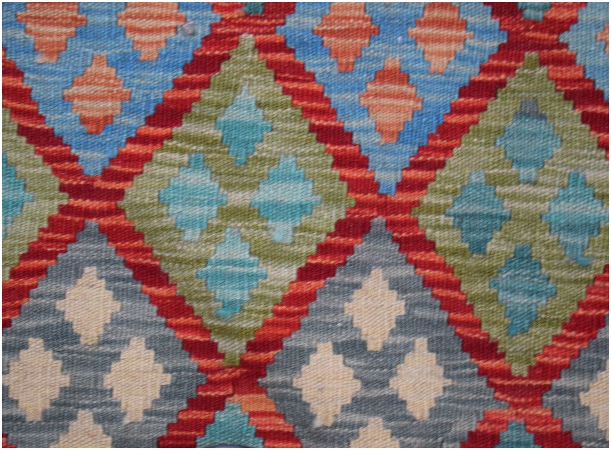 Handwoven Afghan Maimana kilim featuring a geometric diamond pattern in blue, green, and red.