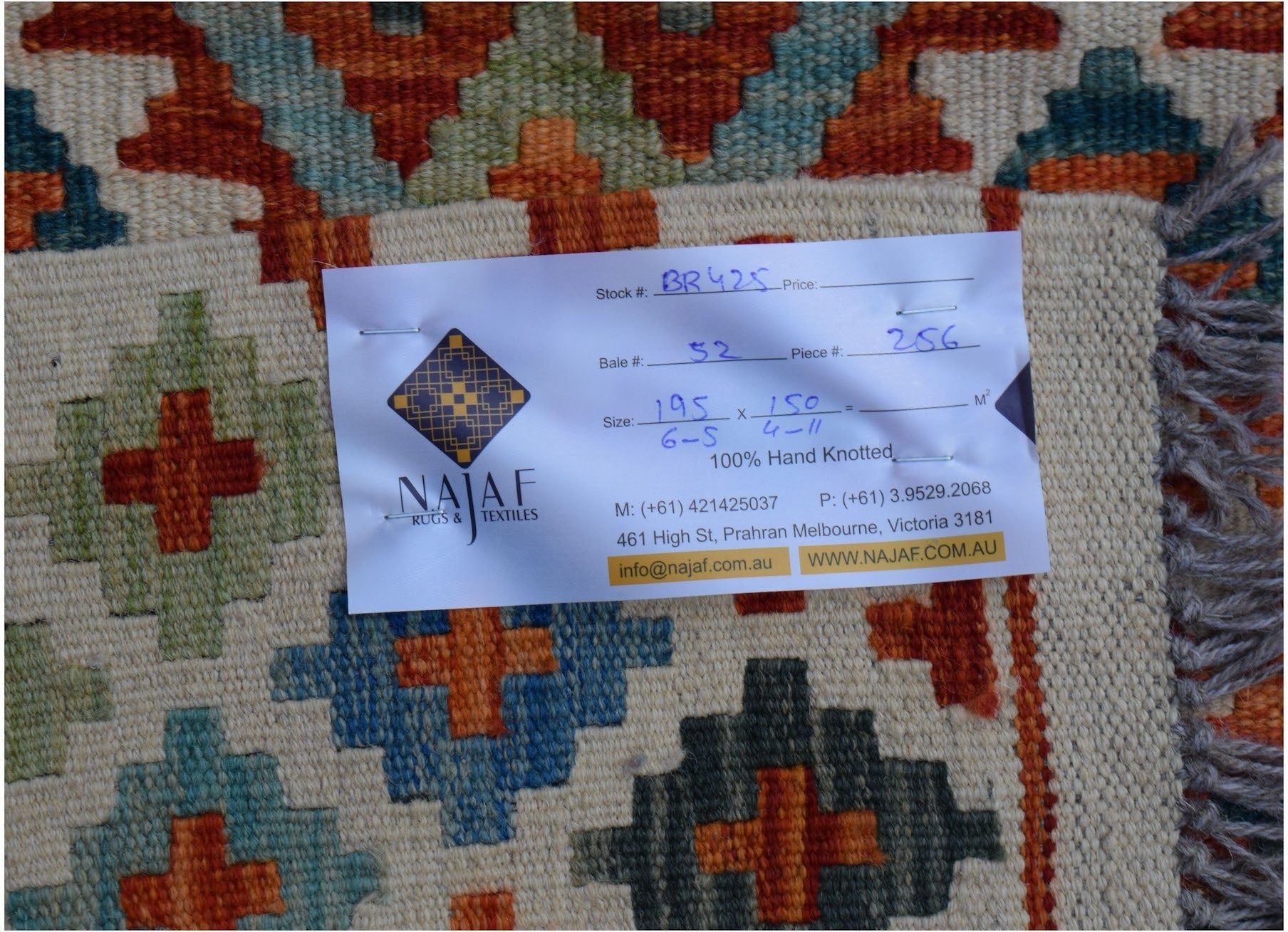 An Afghan Maimana Kilim rug featuring a geometric pattern in orange, blue, and green wool.