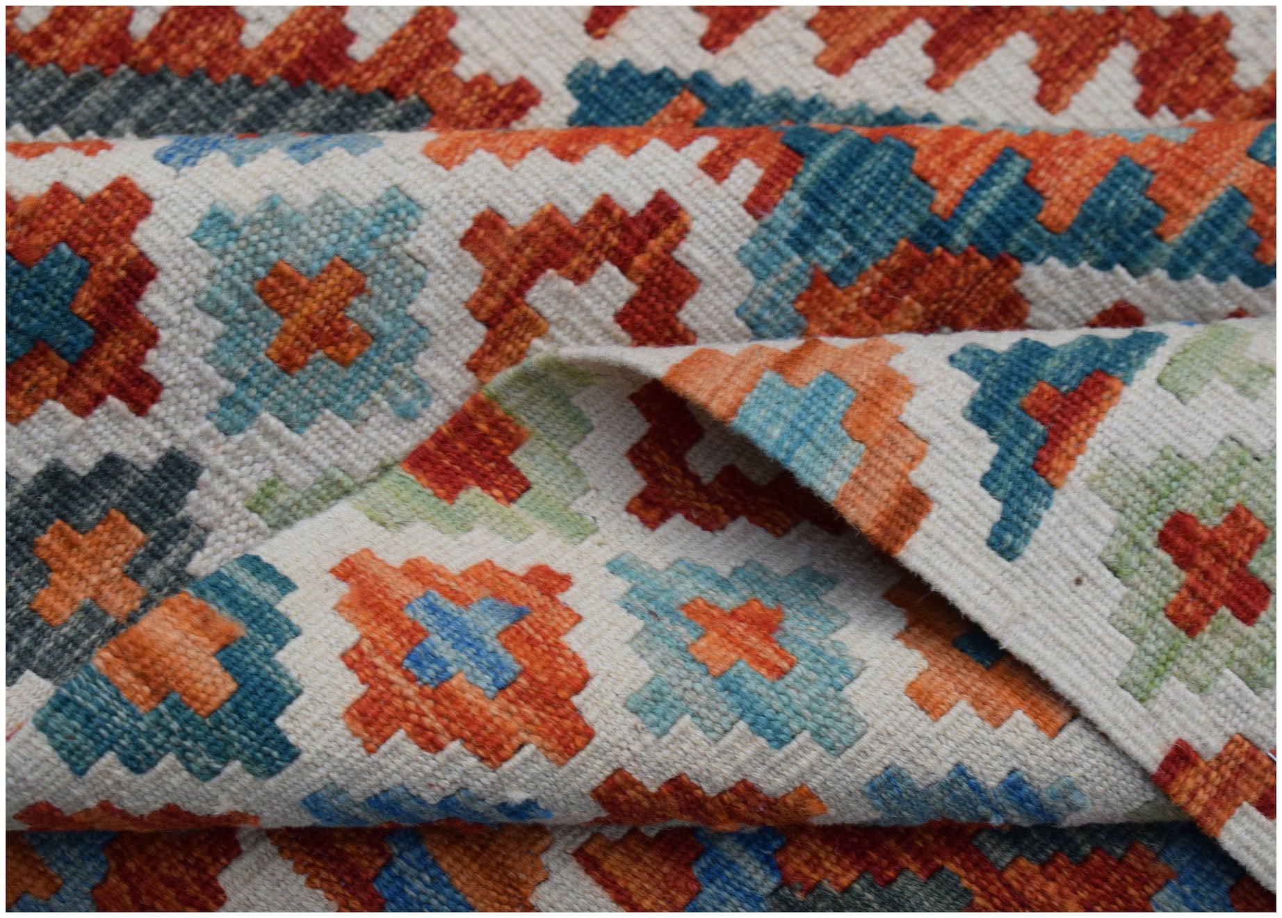 A handmade Afghan Maimana kilim rug featuring a geometric pattern in orange, blue, and green.