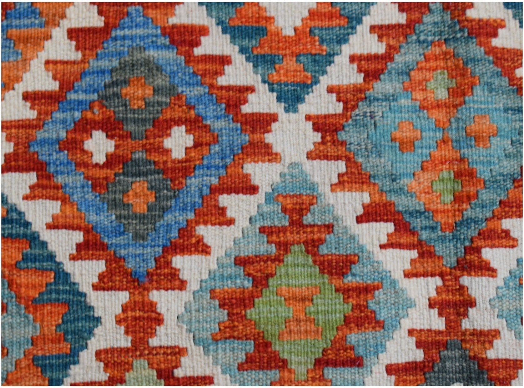 Handwoven Afghan Maimana kilim rug featuring a geometric diamond pattern in vibrant colors.