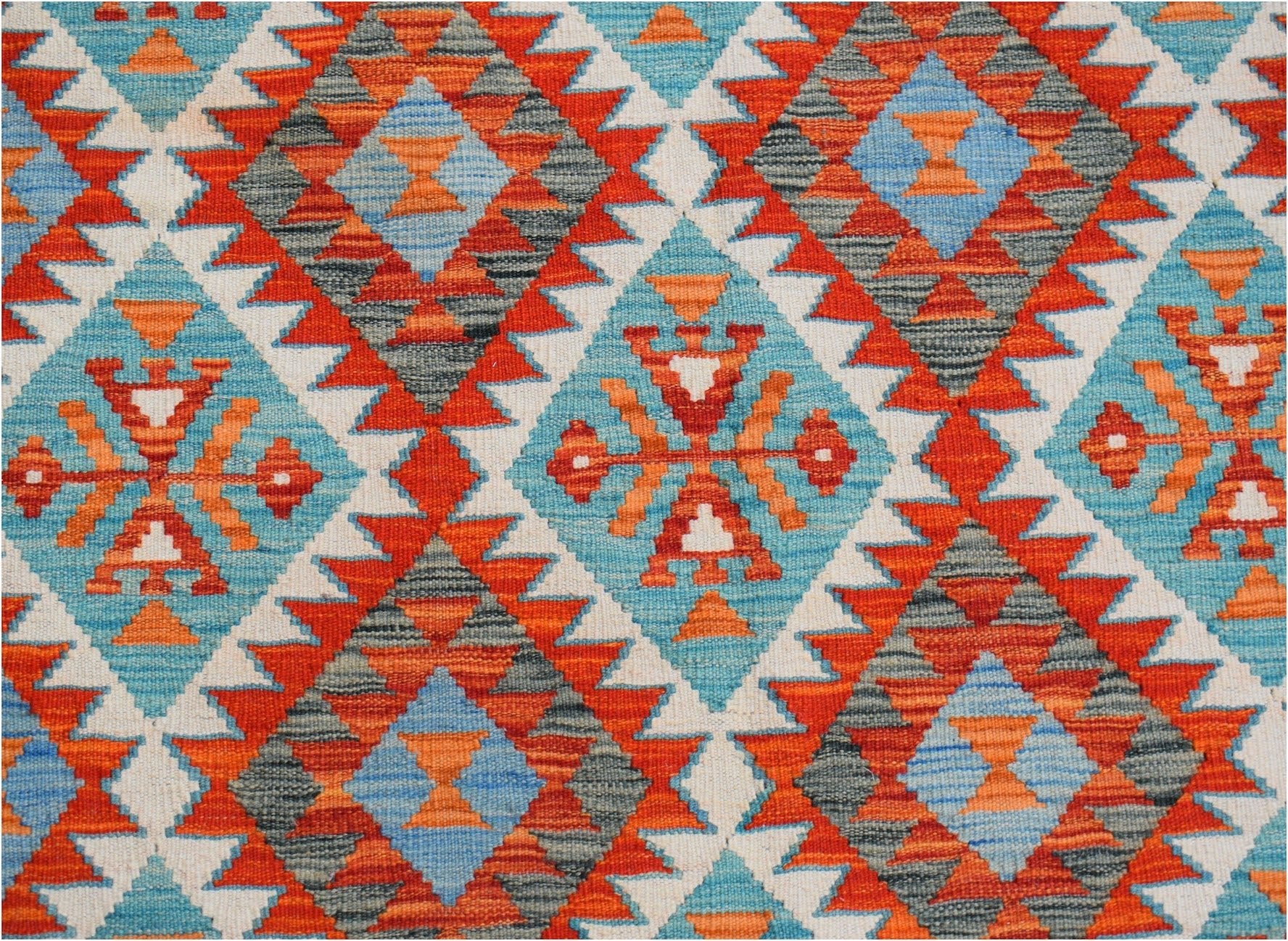 Handwoven Afghan Maimana kilim rug featuring a vibrant geometric pattern in blue, orange, and grey.