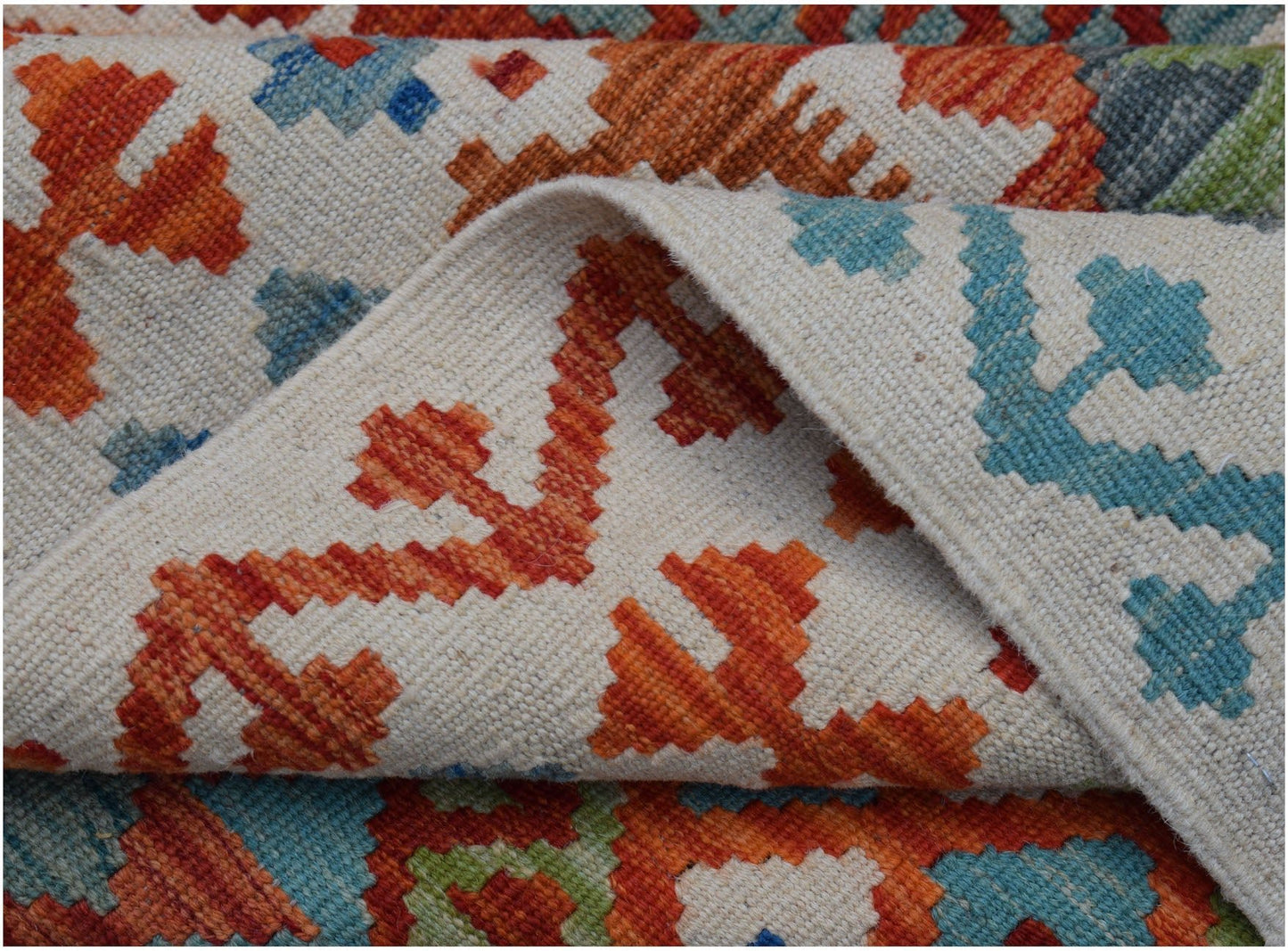 A handwoven Afghan Maimana kilim rug featuring a geometric pattern in orange, blue, and green.