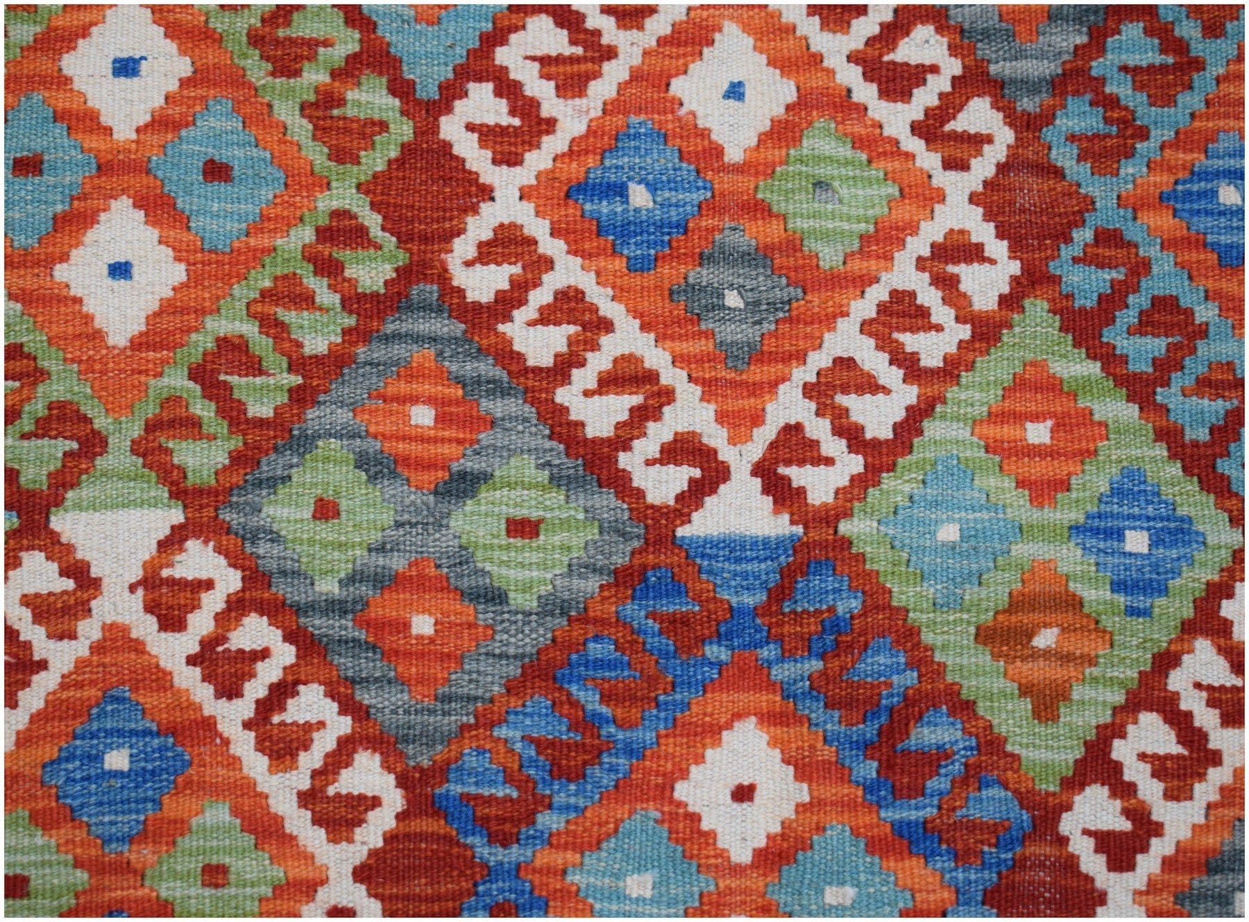 Handwoven Afghan Maimana kilim rug featuring a vibrant geometric diamond pattern in wool.