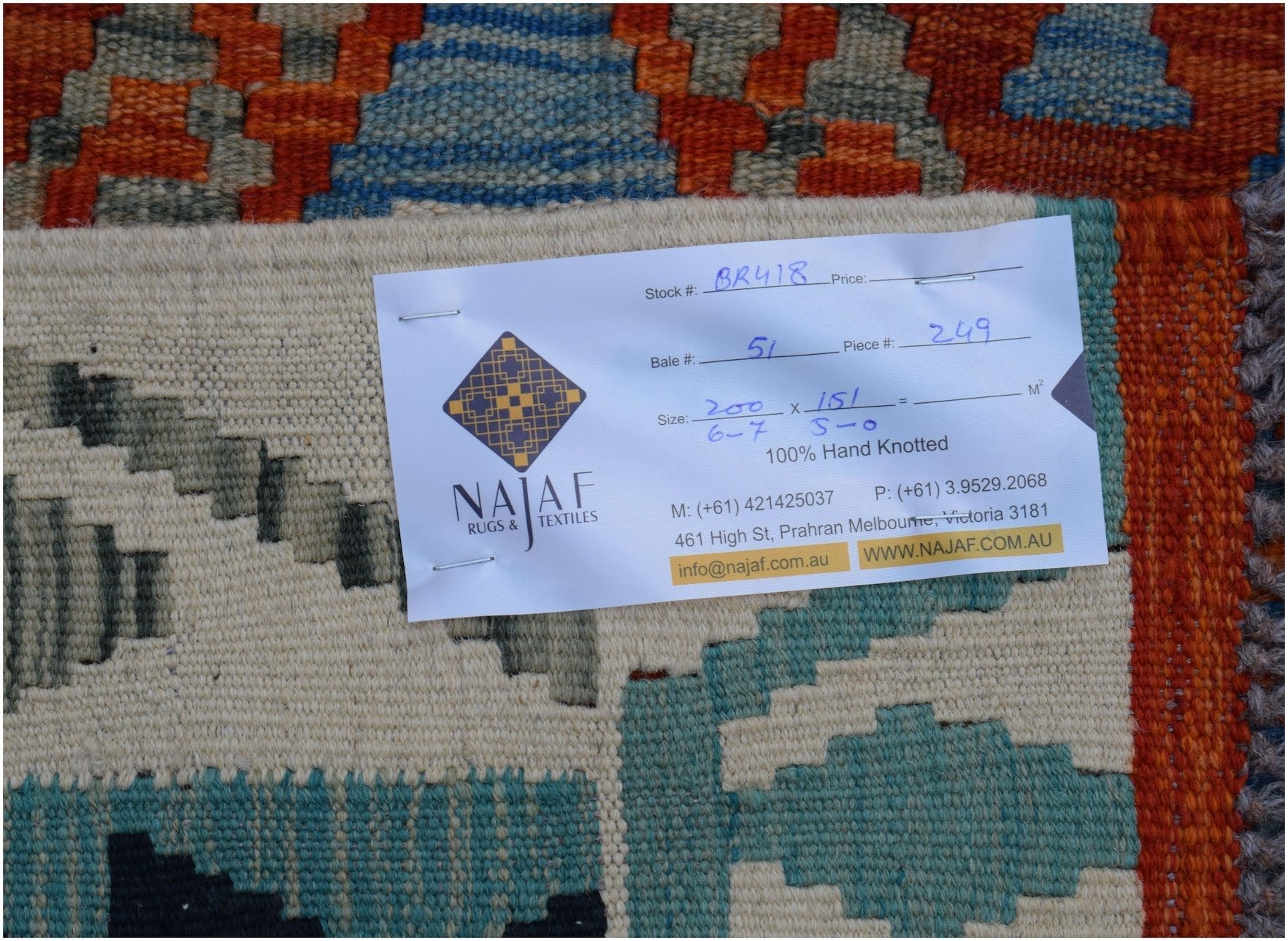 A handwoven Afghan Maimana kilim featuring a geometric pattern in orange, blue, and cream tones.
