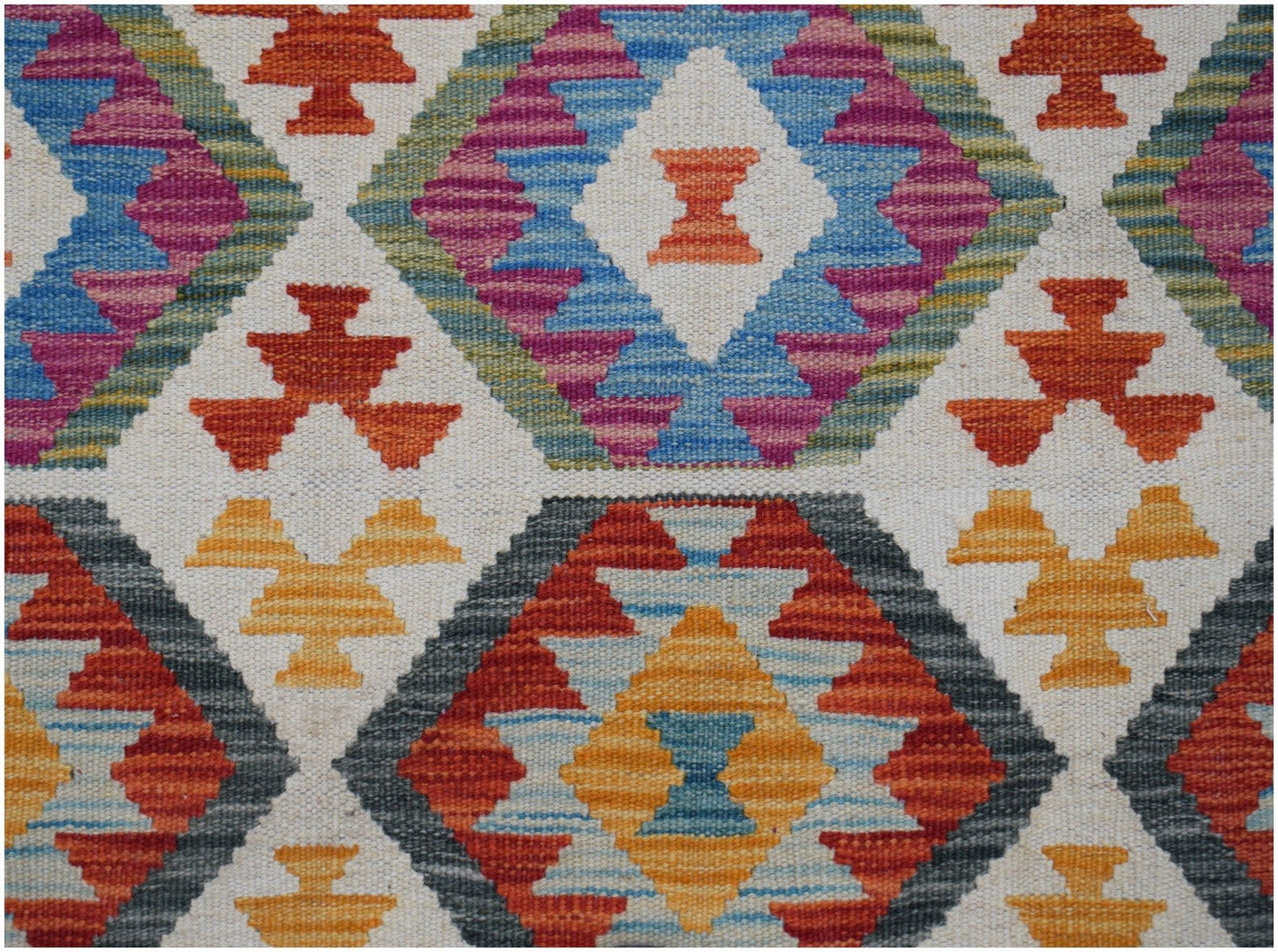 Handwoven Afghan Maimana kilim featuring a geometric diamond pattern in vibrant multicolored wool.