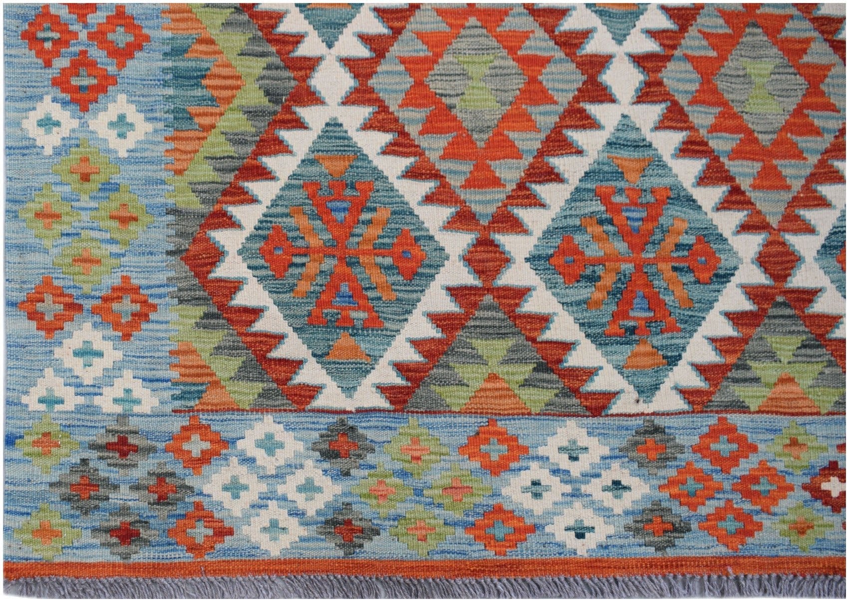 Handwoven Afghan Maimana kilim rug featuring a geometric pattern in blue, orange, and green.