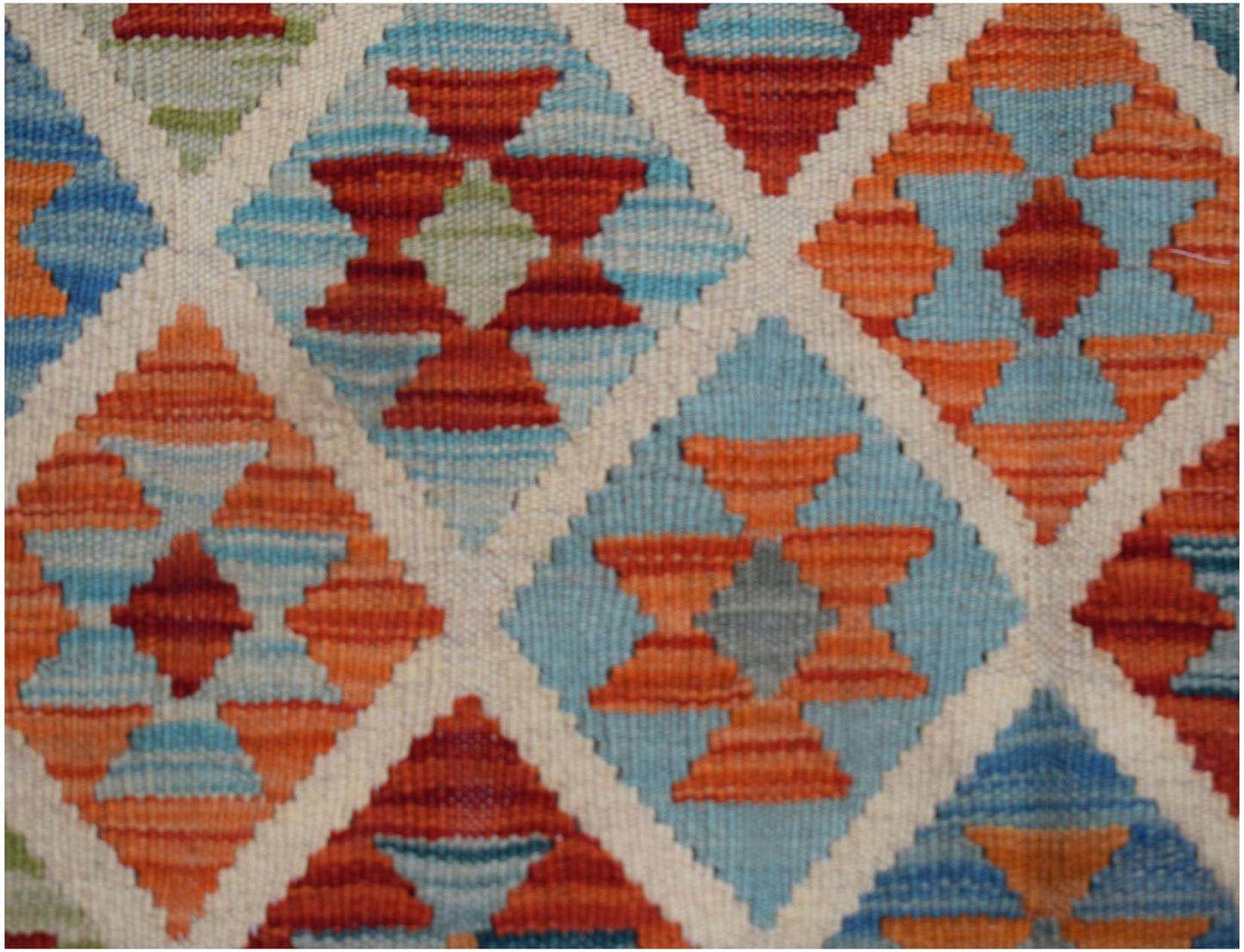 Handwoven Afghan Maimana kilim featuring a geometric diamond pattern in blue, orange, and red.