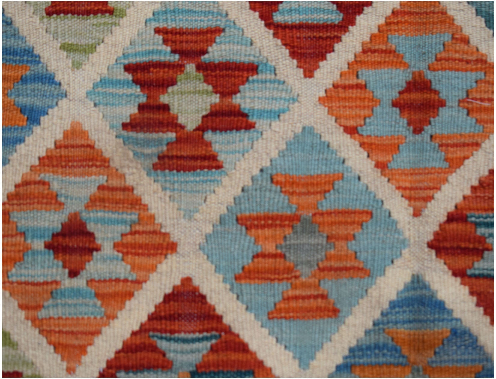 Handwoven Afghan Maimana kilim featuring a geometric diamond pattern in blue, orange, and red.