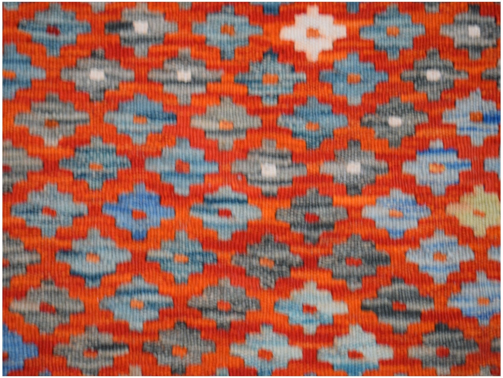 Handwoven Afghan Maimana kilim featuring a repeating geometric diamond pattern in orange and blue.