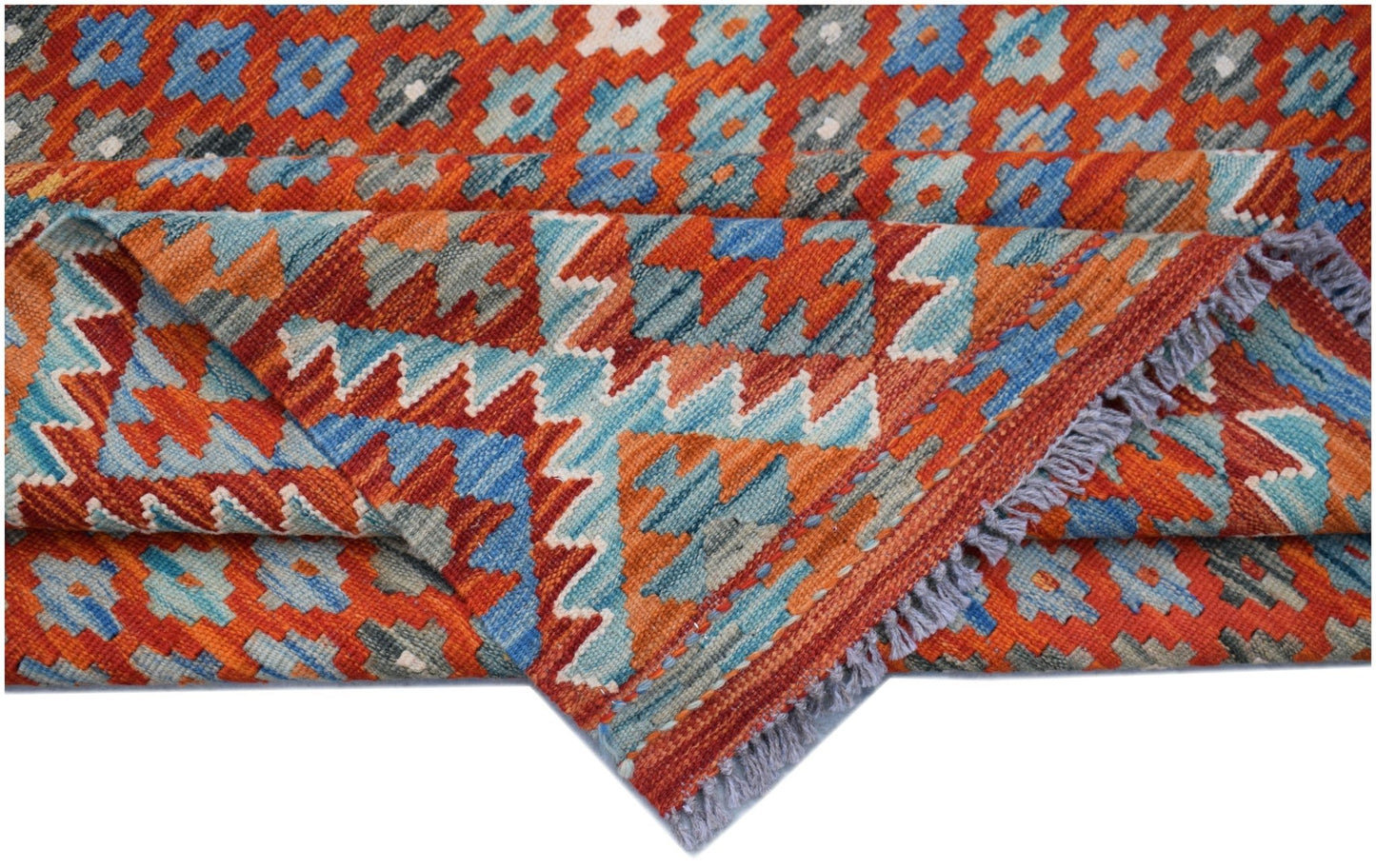 A handwoven Afghan Maimana kilim rug featuring a geometric pattern in orange, blue, and grey.