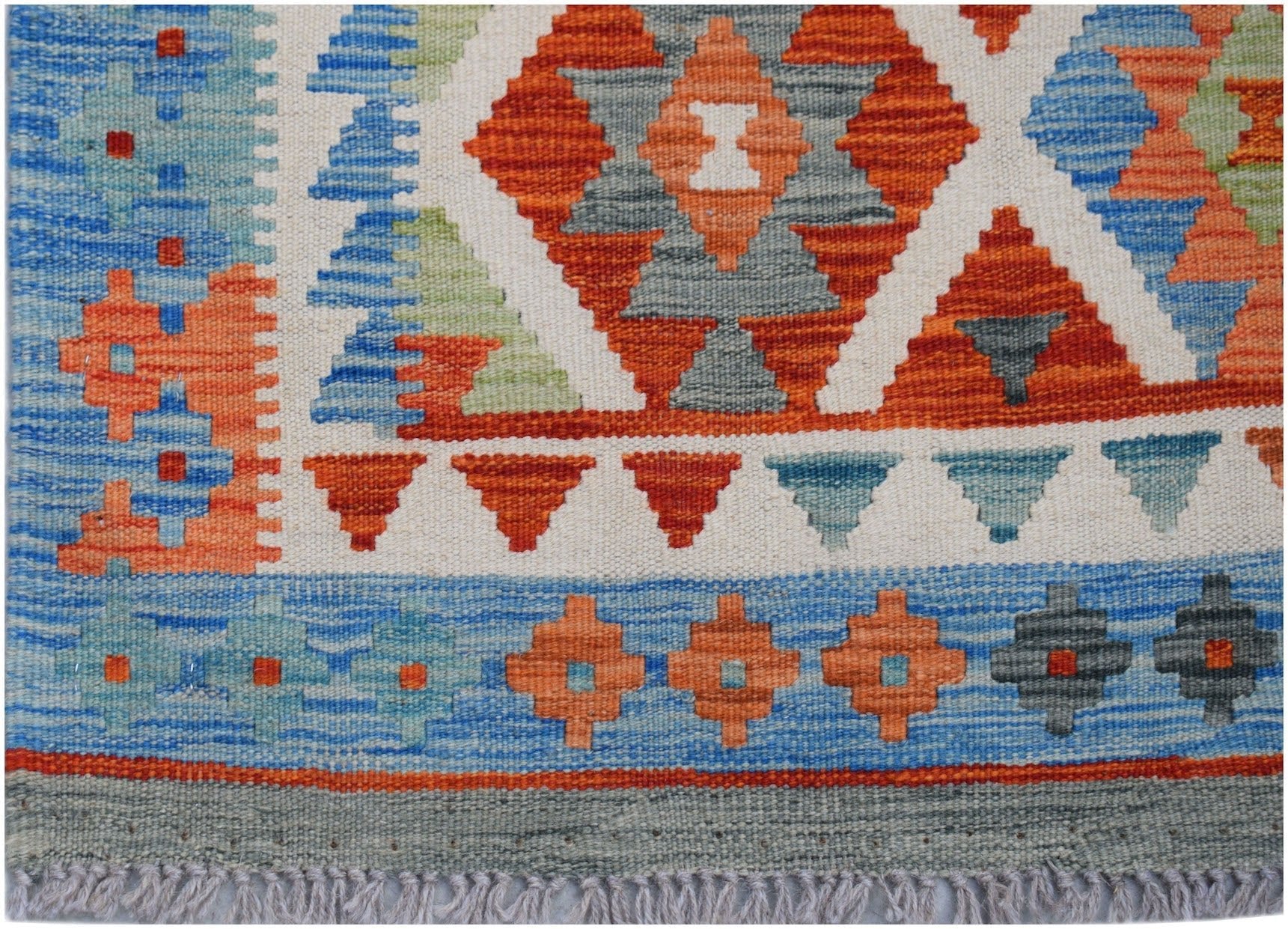 Handwoven Afghan Maimana kilim rug featuring geometric patterns in orange, blue, and grey wool.
