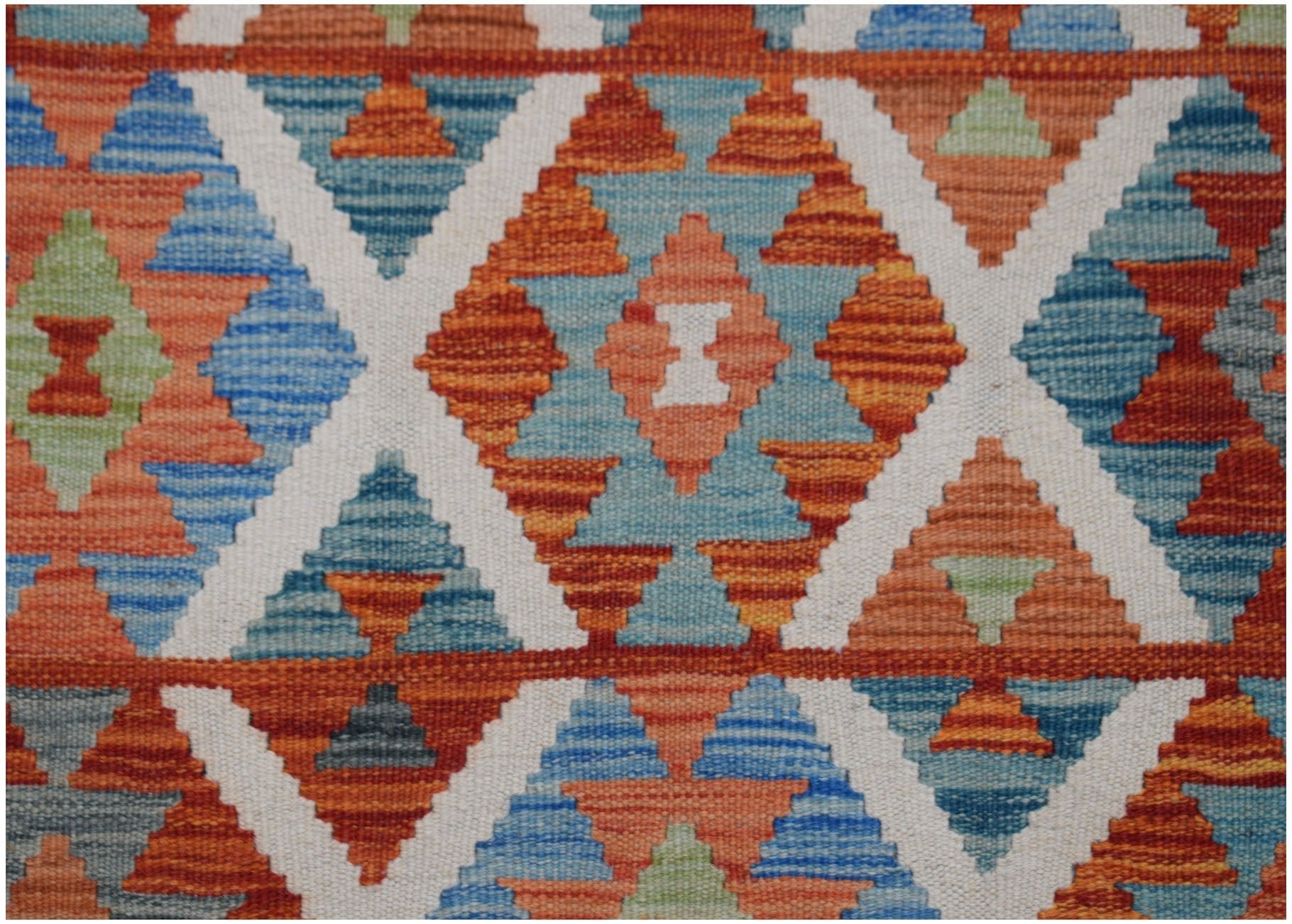 Handwoven Afghan Maimana kilim rug featuring a geometric diamond pattern in vibrant colors.