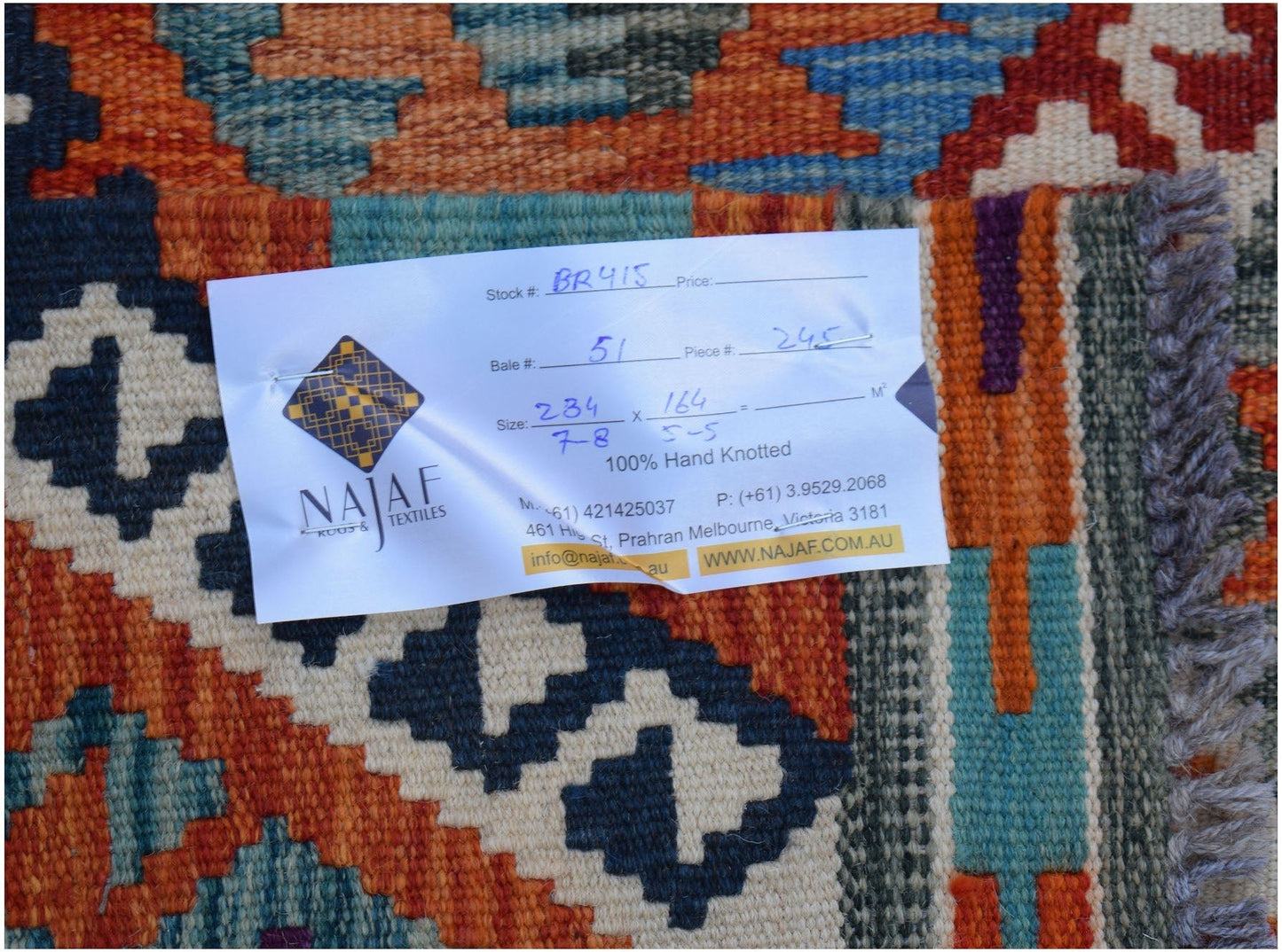 A flatwoven Afghan Maimana kilim featuring a vibrant geometric pattern in orange, blue, and cream.