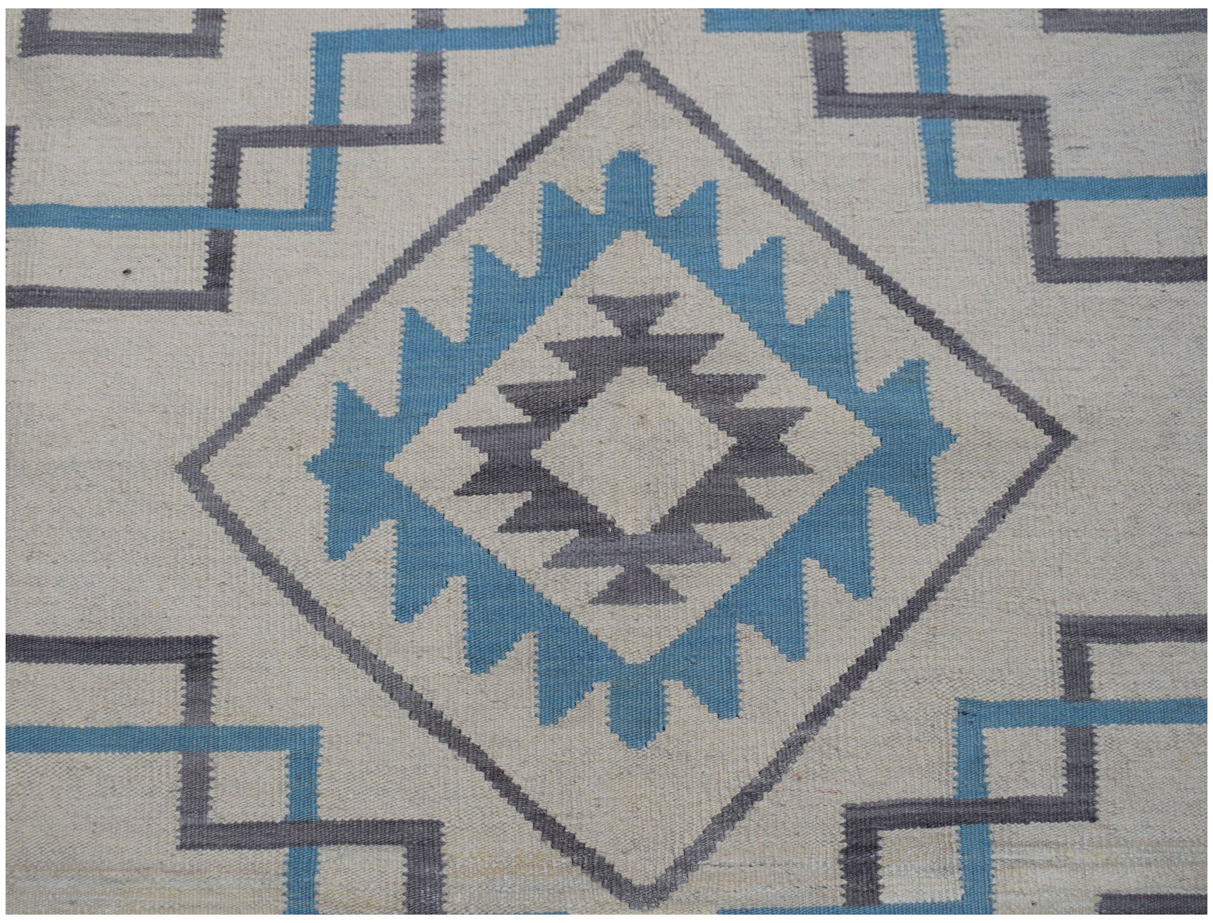 Handwoven Afghan Maimana kilim featuring a geometric diamond pattern in blue and grey on cream.