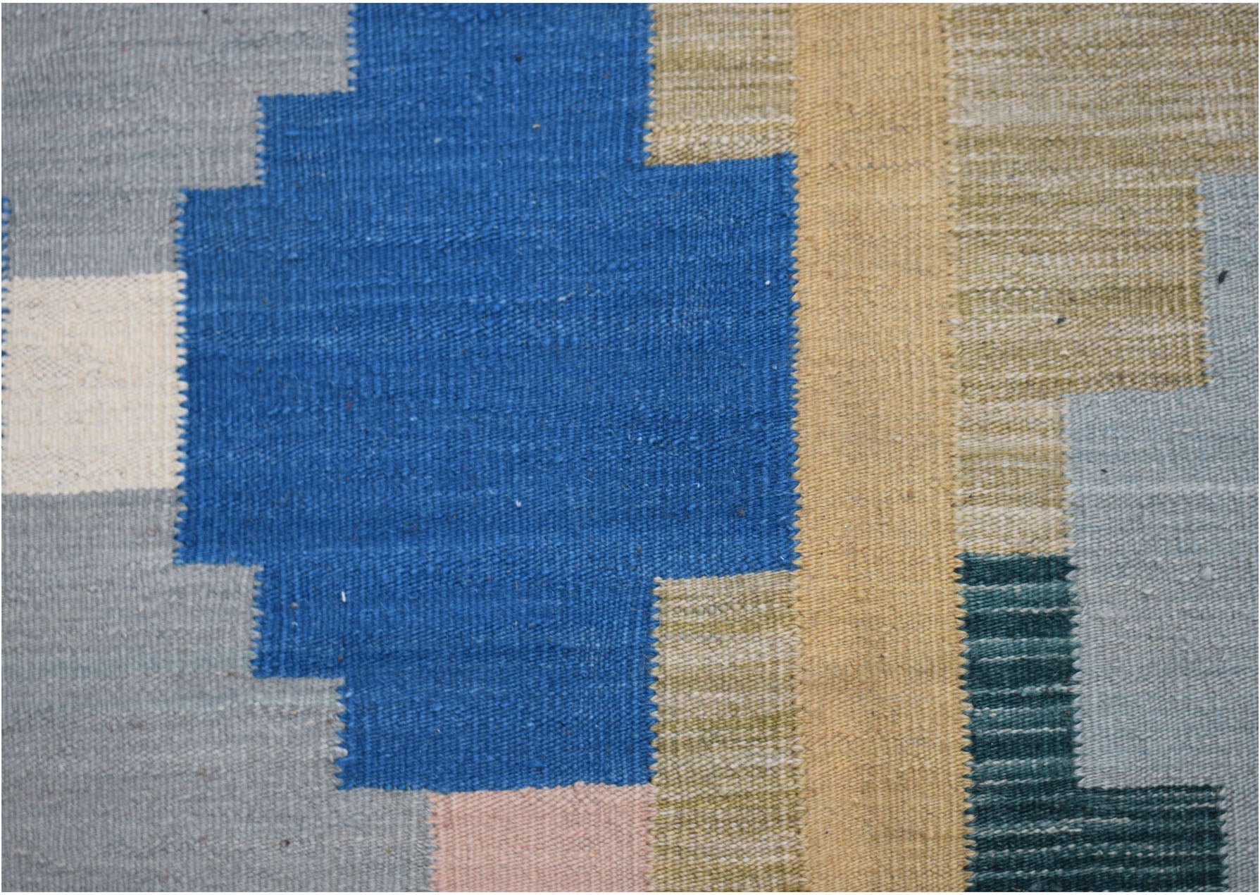 Handwoven Afghan Maimana kilim rug featuring a geometric pattern in blue, tan, and grey tones.