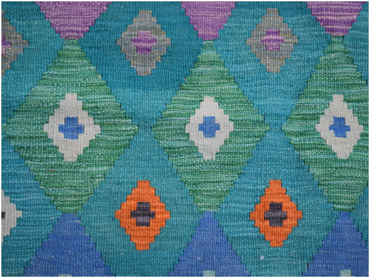 Handwoven Afghan Maimana kilim rug featuring a geometric diamond pattern in vibrant colors.