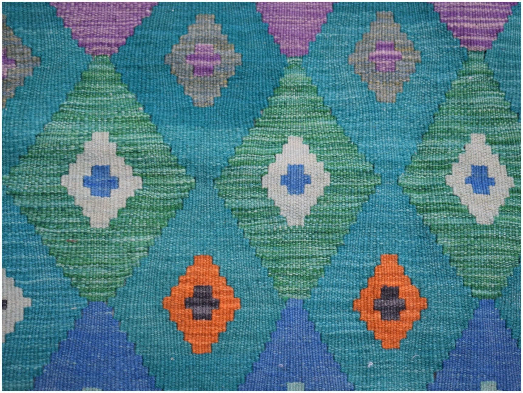 Handwoven Afghan Maimana kilim rug featuring a geometric diamond pattern in vibrant colors.