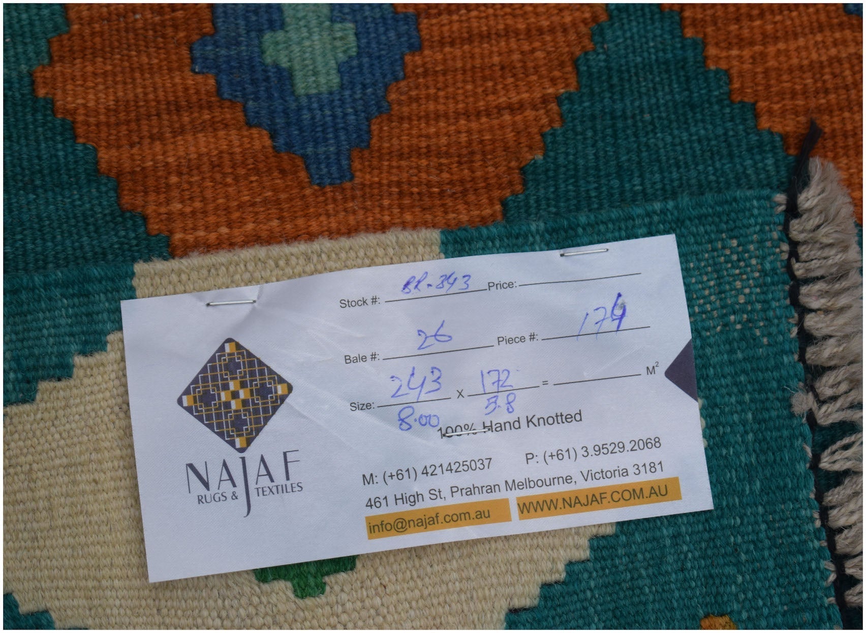 A flatwoven Afghan Maimana kilim rug featuring a geometric pattern in teal, orange, and cream.