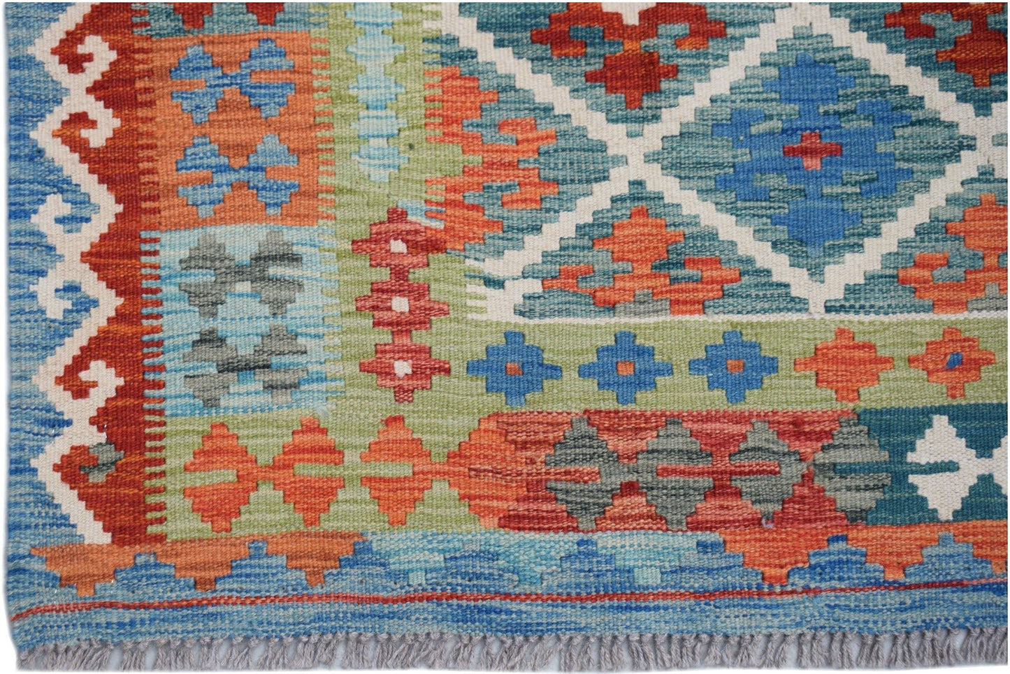 Handwoven Afghan Maimana kilim rug featuring a geometric pattern in vibrant blue, red, and green.