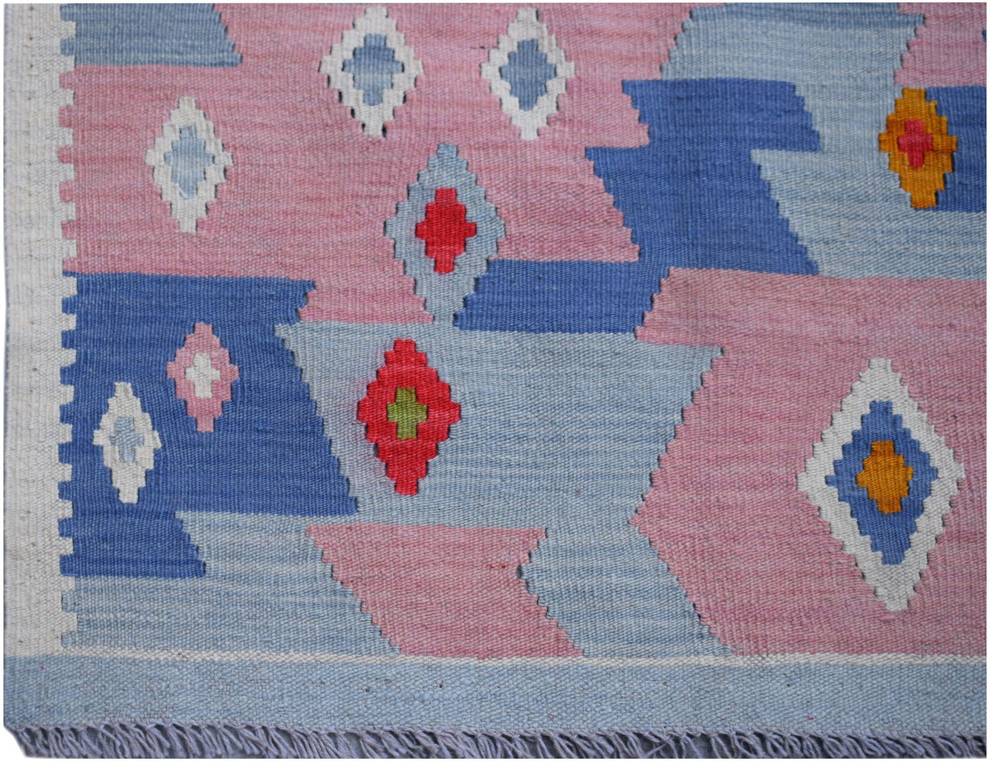 Handwoven Afghan Maimana kilim rug featuring a geometric pattern in pink, blue, and white.