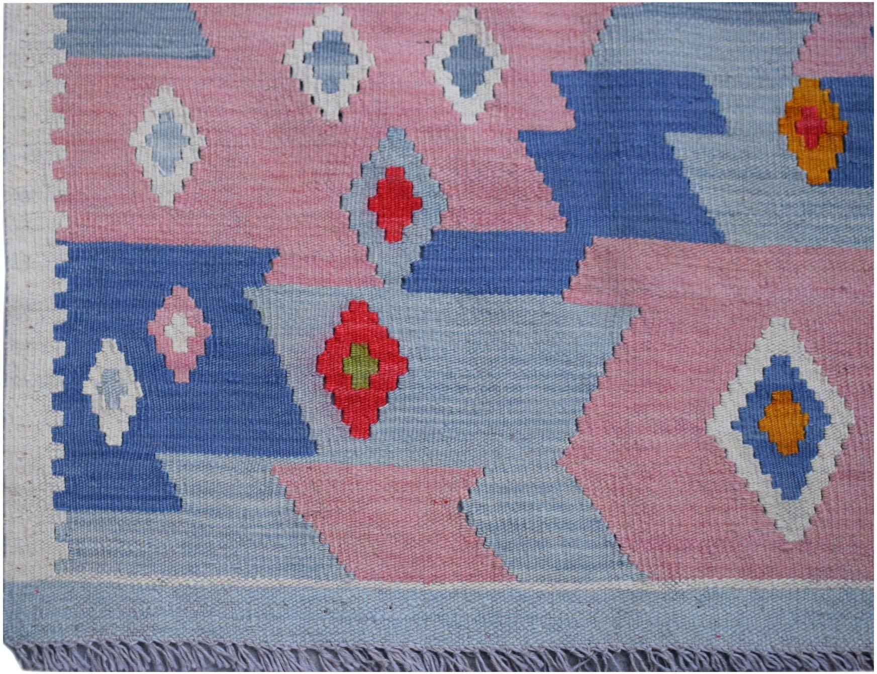 Handwoven Afghan Maimana kilim rug featuring a geometric pattern in pink, blue, and white.