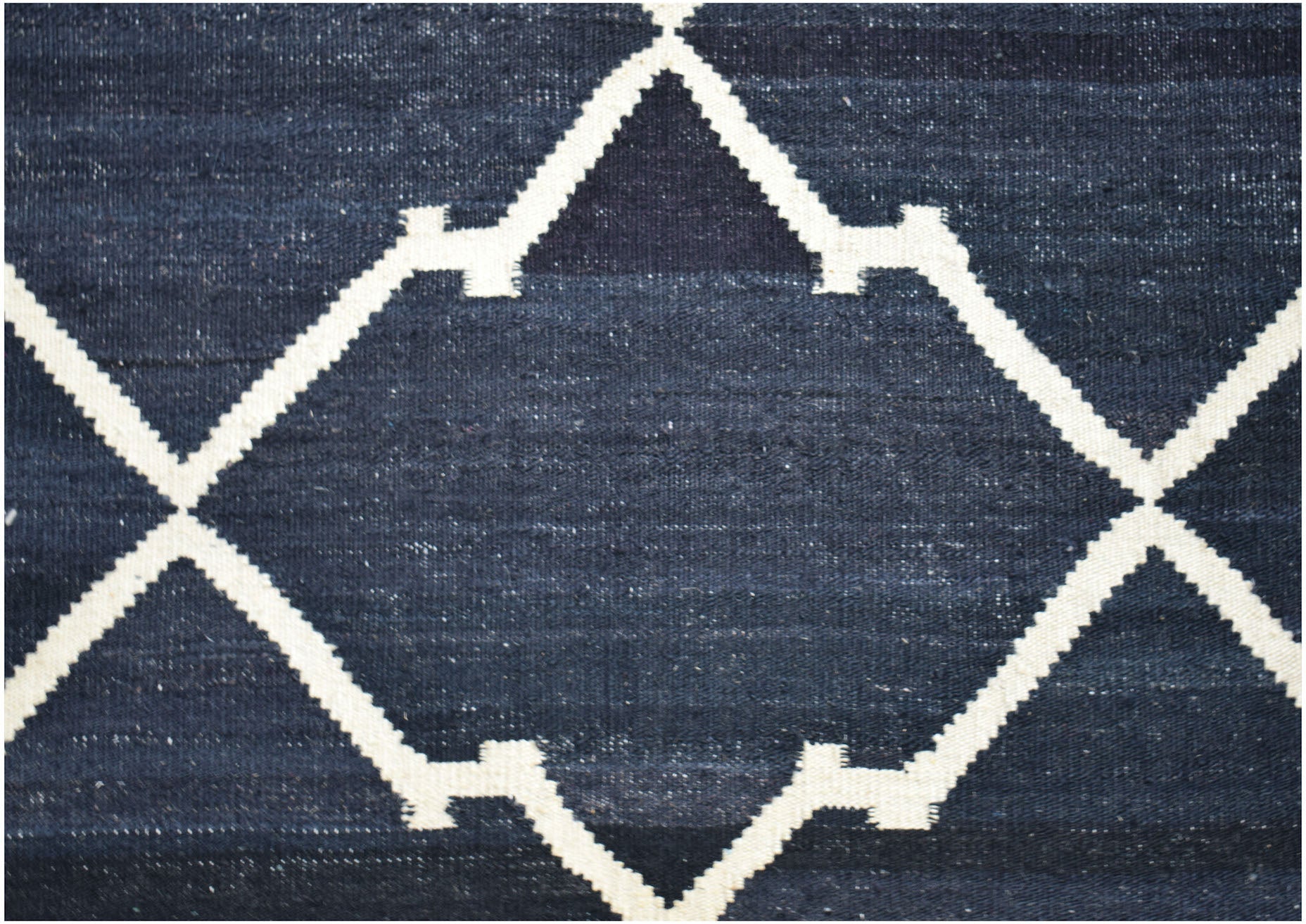Handwoven Afghan Maimana kilim rug featuring a dark blue field with a white geometric lattice.