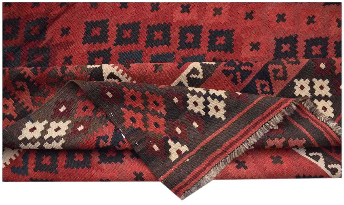 A handmade Afghan Maimana kilim rug featuring geometric patterns in red, black, and cream wool.