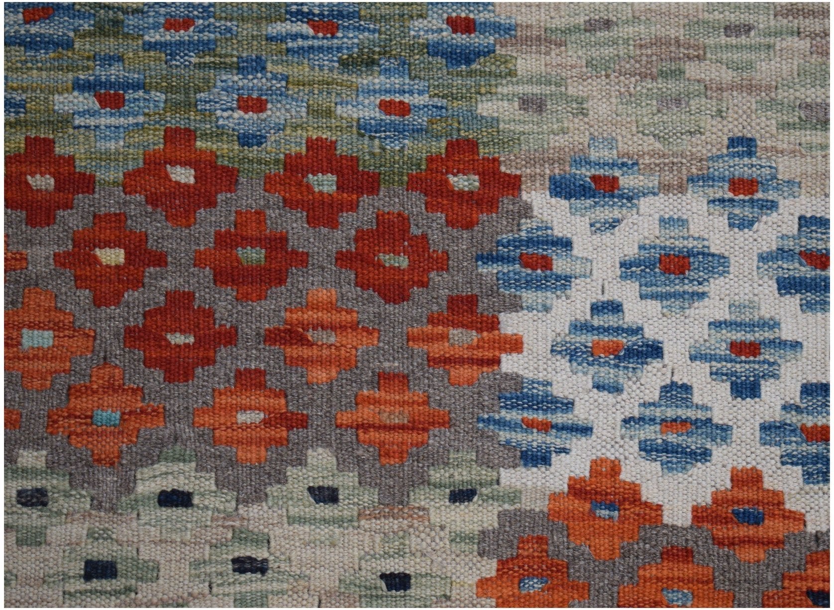 Handwoven Afghan Maimana kilim rug featuring a geometric pattern in vibrant, multicolored tones.
