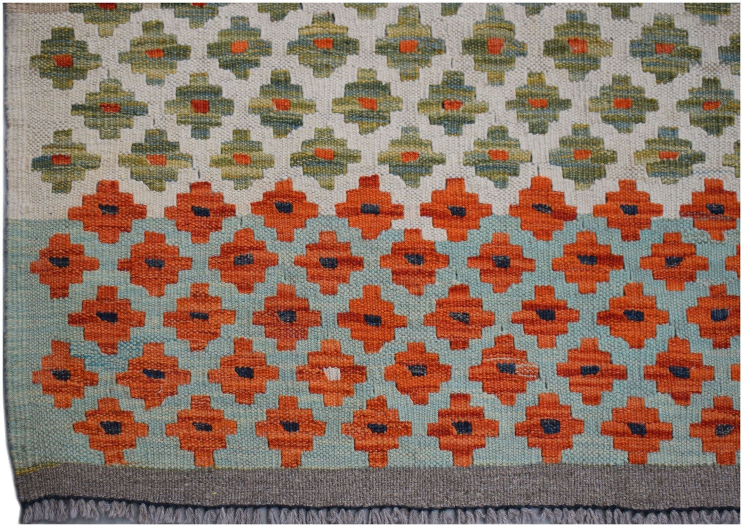 Handwoven Afghan Maimana kilim rug featuring a geometric pattern in orange, green, and blue.