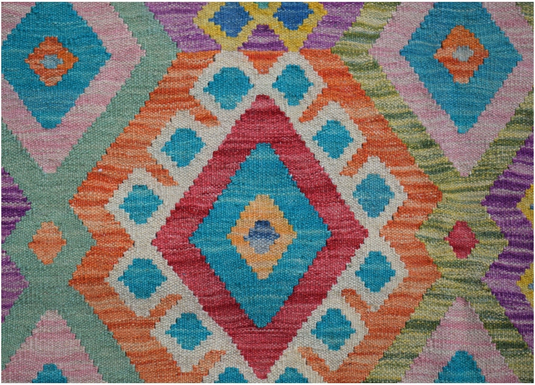 Handwoven Afghan Maimana kilim rug featuring a vibrant geometric diamond pattern in wool.