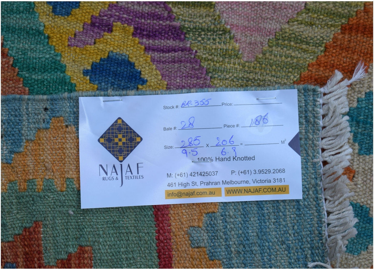 A colorful Afghan Maimana kilim rug featuring a geometric pattern and a flatweave texture.