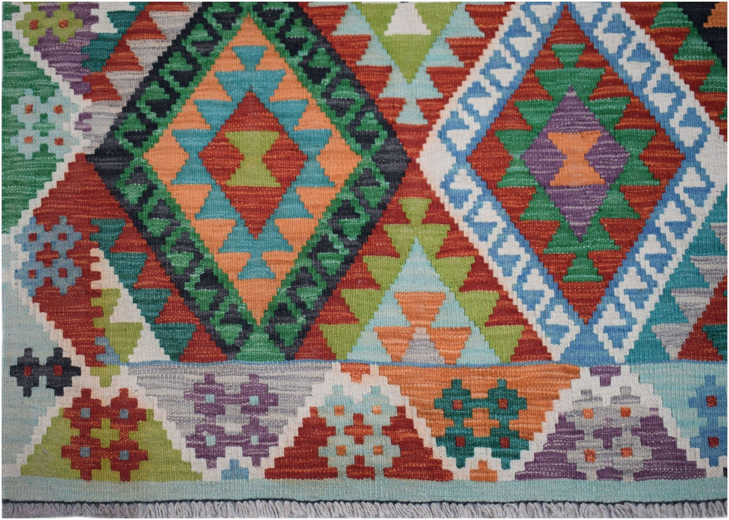 Handwoven Afghan Maimana kilim rug featuring a vibrant geometric pattern in wool.