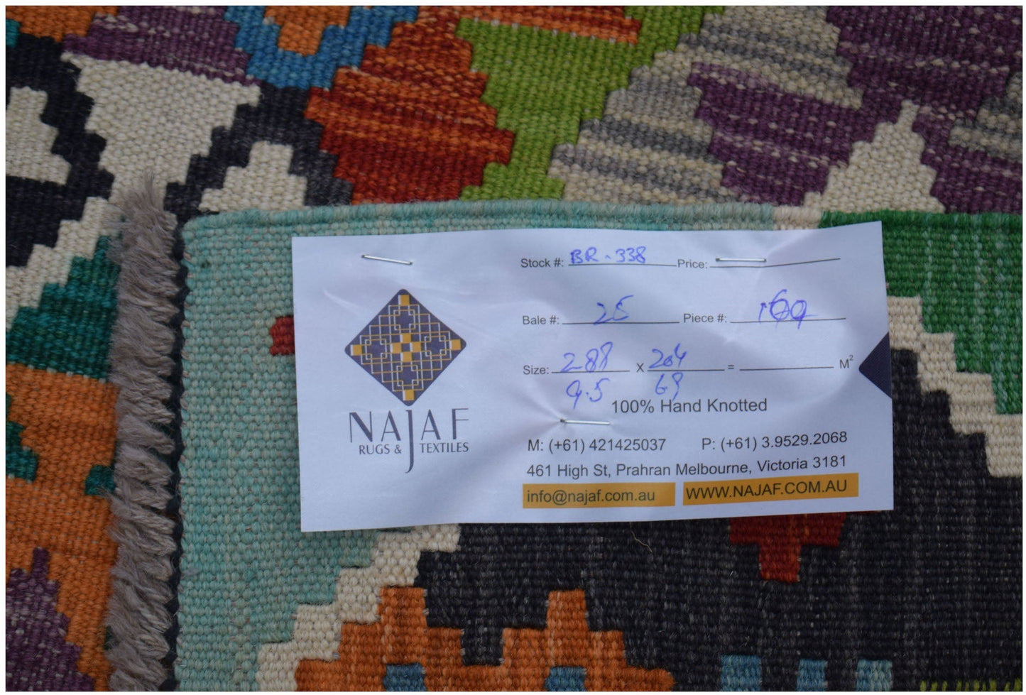 A handwoven Afghan Maimana kilim featuring a vibrant geometric pattern in wool.
