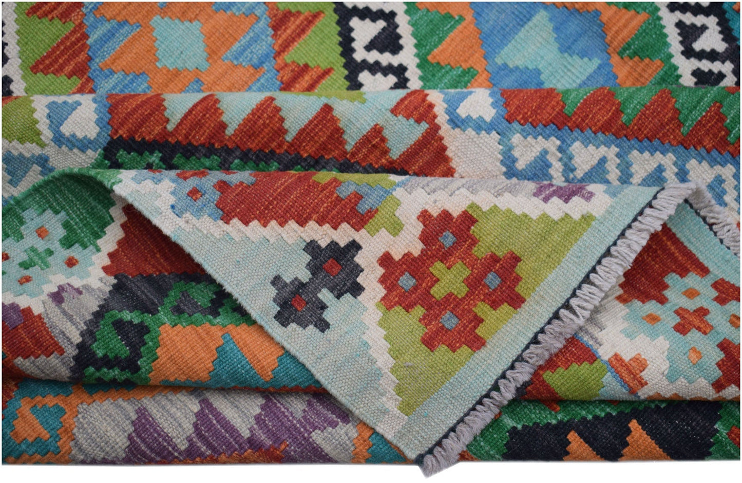 A handwoven Afghan Maimana kilim rug featuring vibrant geometric patterns in wool.