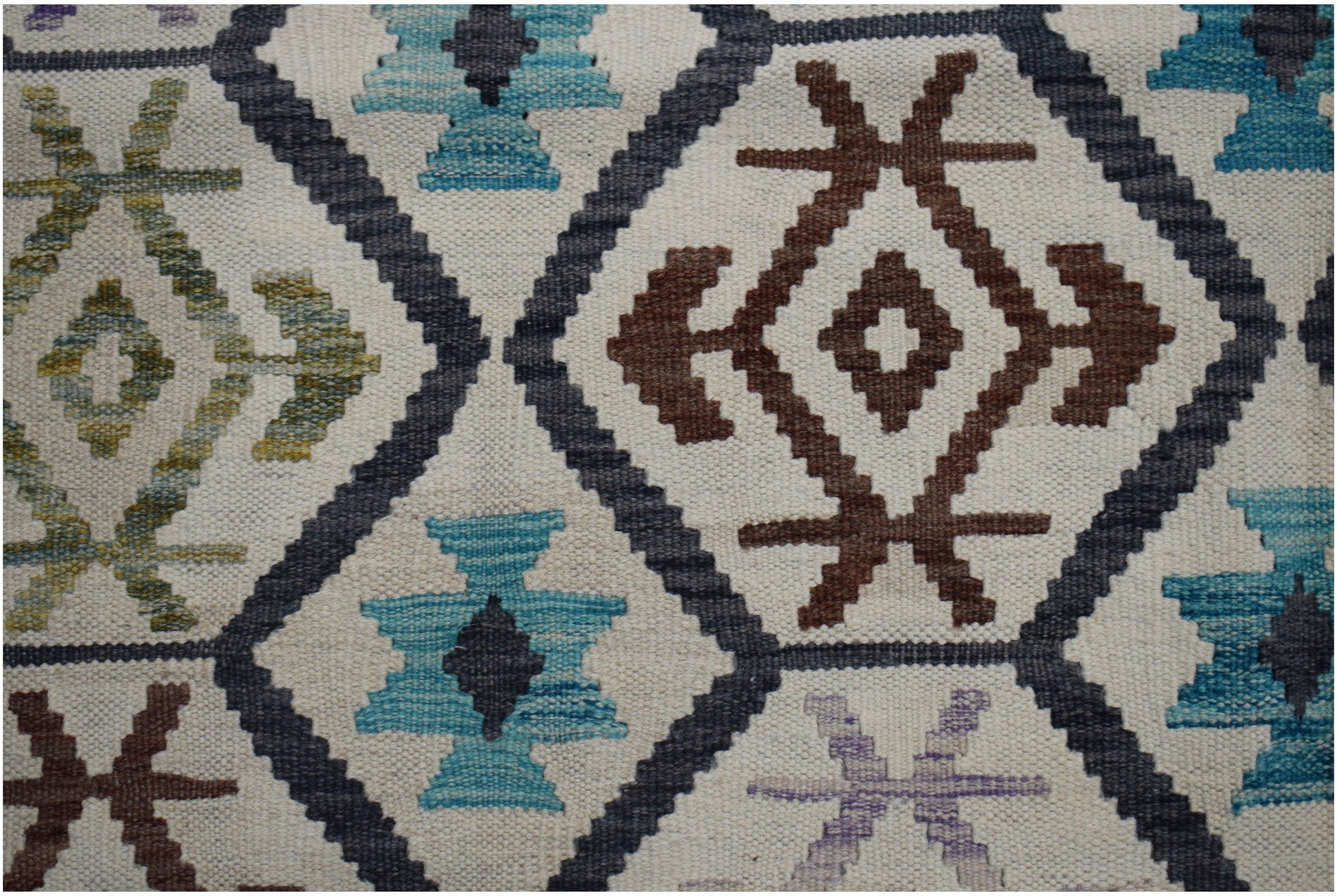 Handwoven Afghan Maimana kilim rug featuring a geometric pattern in blue, brown, and cream tones.