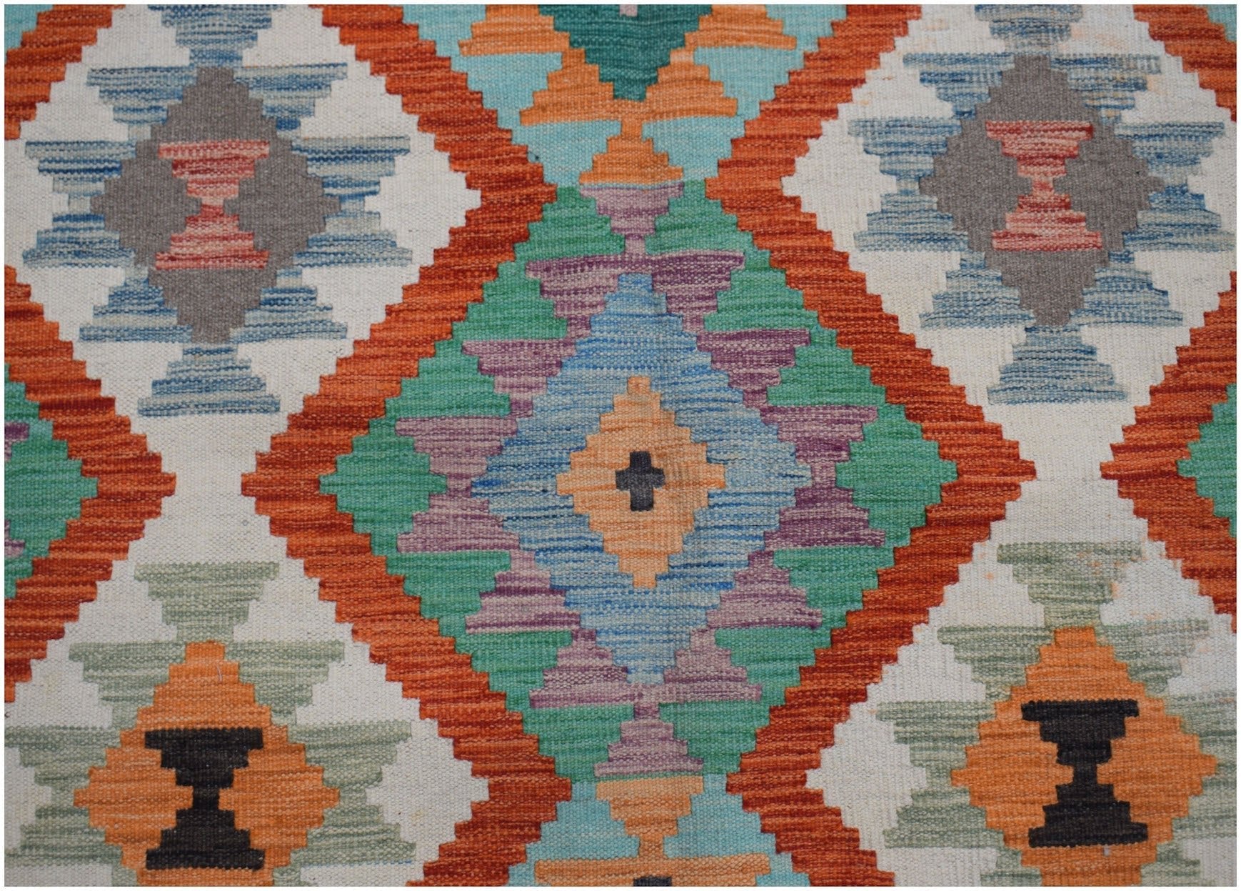 Handwoven Afghan Maimana kilim rug featuring a vibrant geometric diamond pattern in wool.