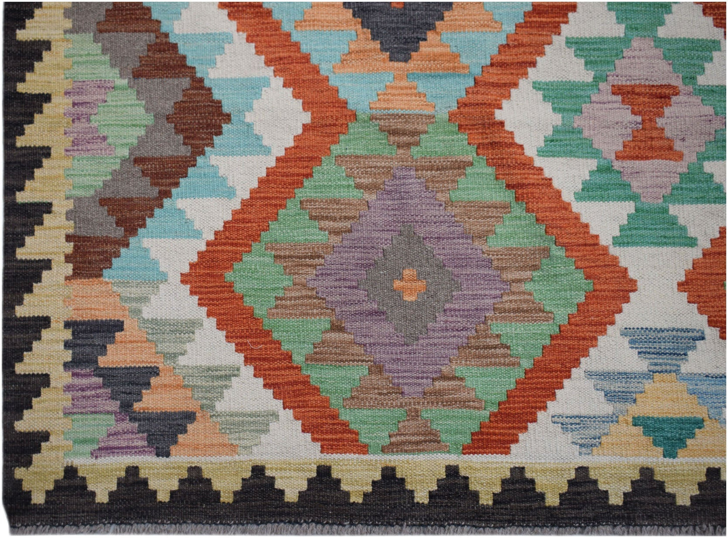 Handwoven Afghan Maimana kilim rug featuring a colorful geometric diamond pattern in wool.