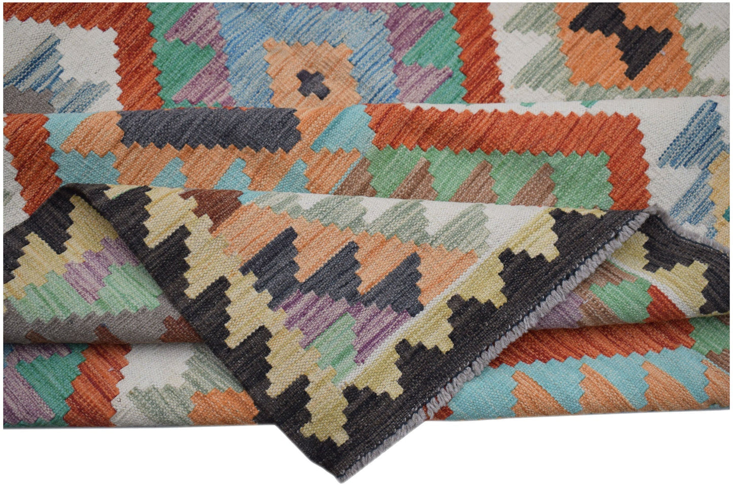 A handwoven Afghan Maimana kilim rug featuring a colorful geometric pattern in wool.