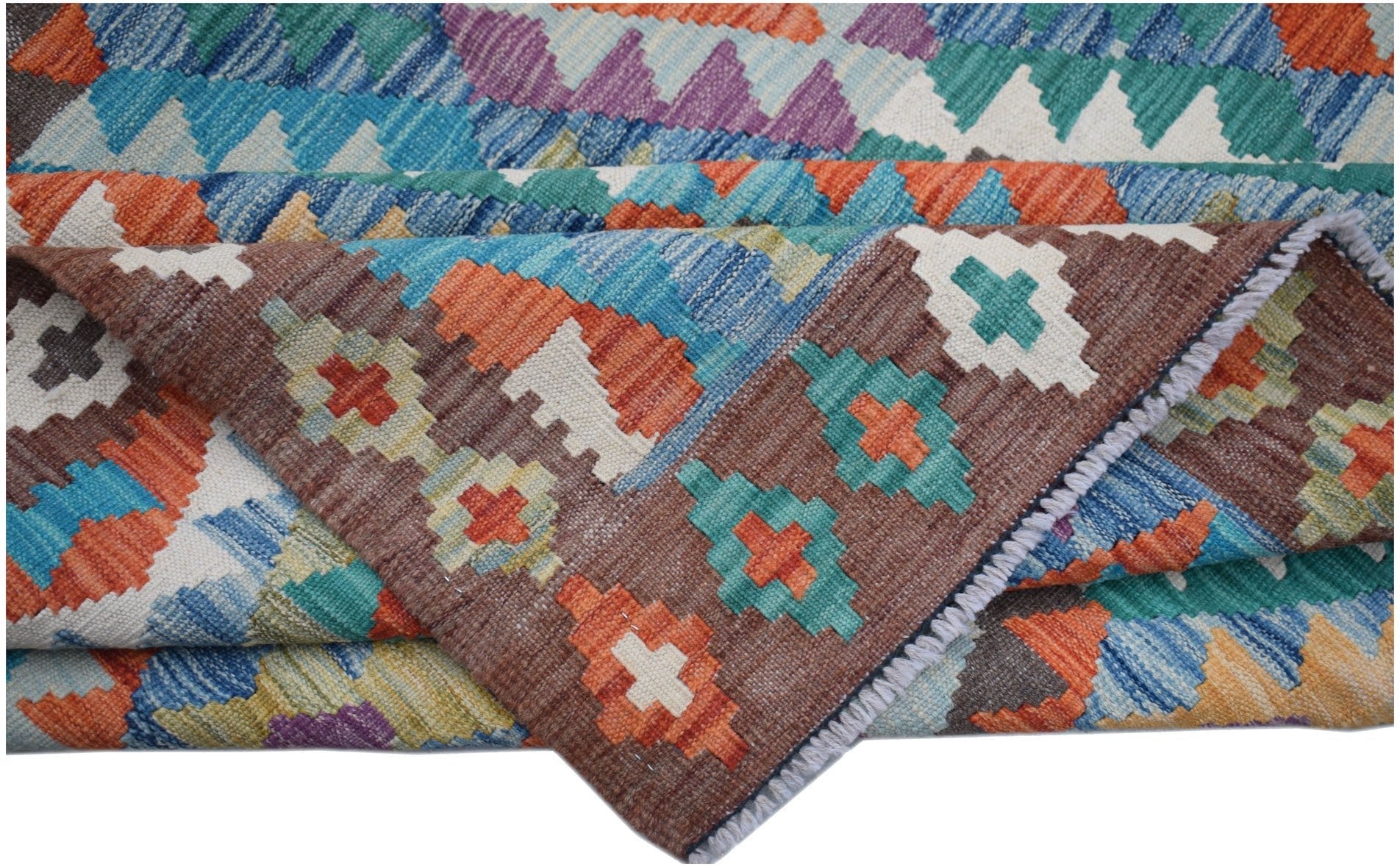 A handmade Afghan Maimana kilim rug featuring a colorful geometric pattern on a brown background.