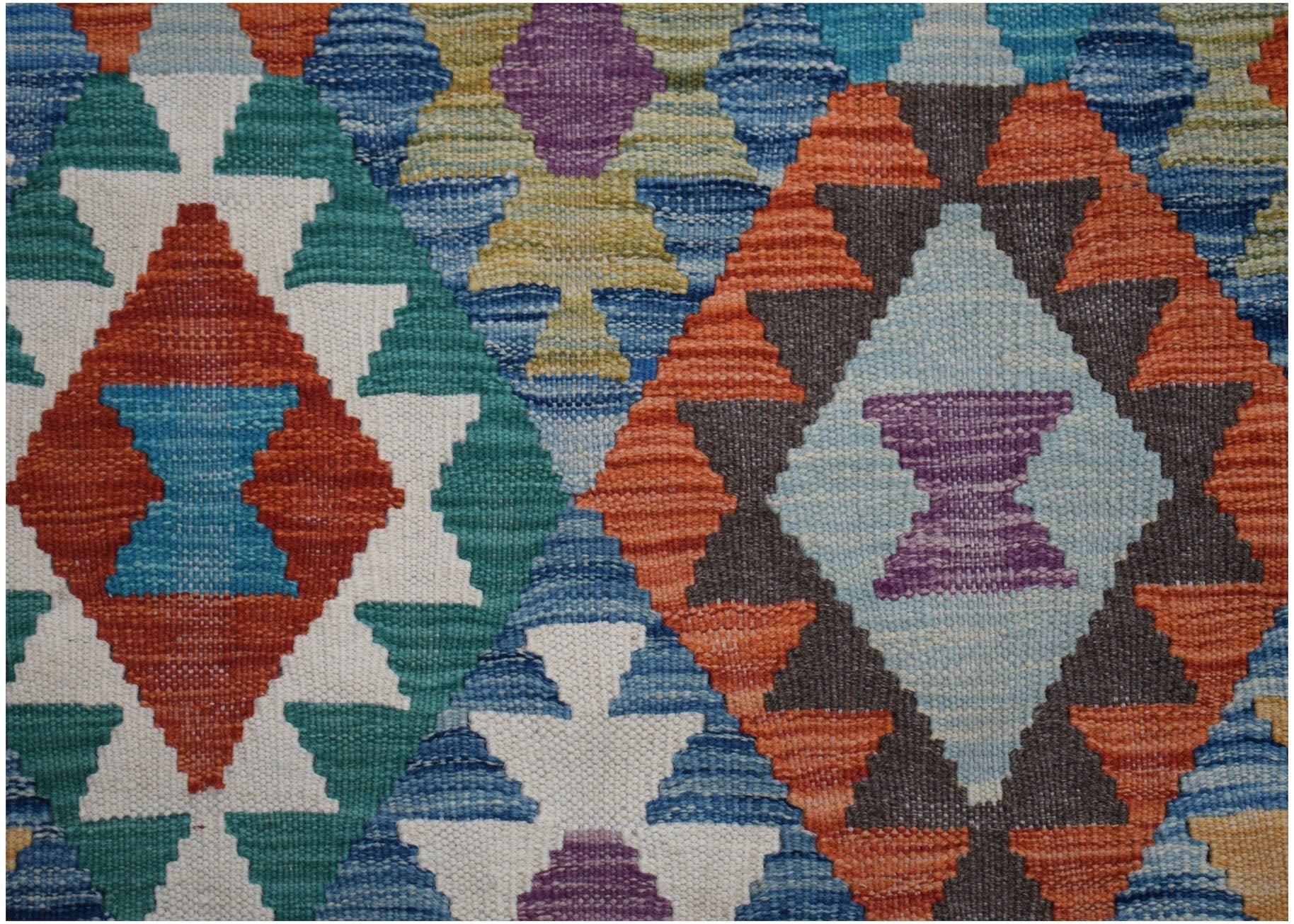Handwoven Afghan Maimana kilim rug featuring a vibrant geometric diamond pattern in wool.