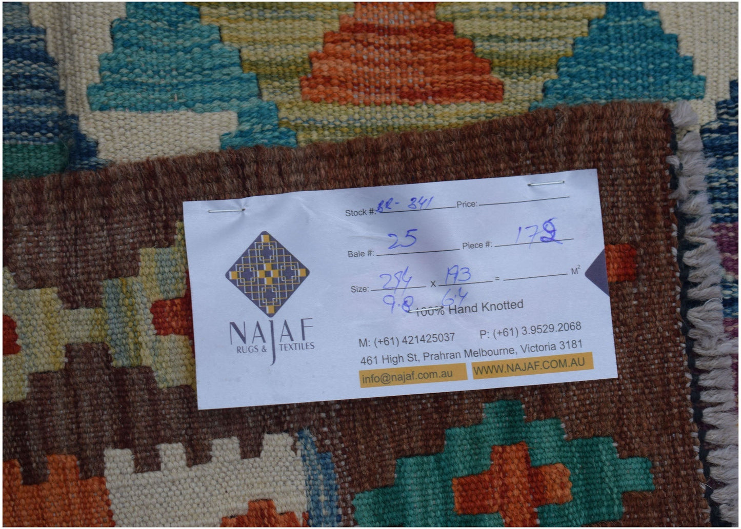 A handmade Afghan Maimana kilim rug featuring a colorful geometric pattern on a wool base.